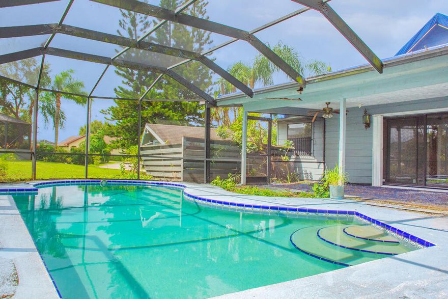 Located on a corner lot in the heart of Port St. Lucie, this frame construction pool home offers unique architectural details and incredible potential. The interior features cathedral-style cedar tongue-and-groove ceilings, two fireplaces (one in the living room and one in the converted bar/entertainment area), and a spacious kitchen perfect for future renovations and entertaining. The garage has been converted into a game room with a bar , adding flexible living space. Buyer to verify exposure all measurements are approximate NO SITE UNSEEN OFFERS