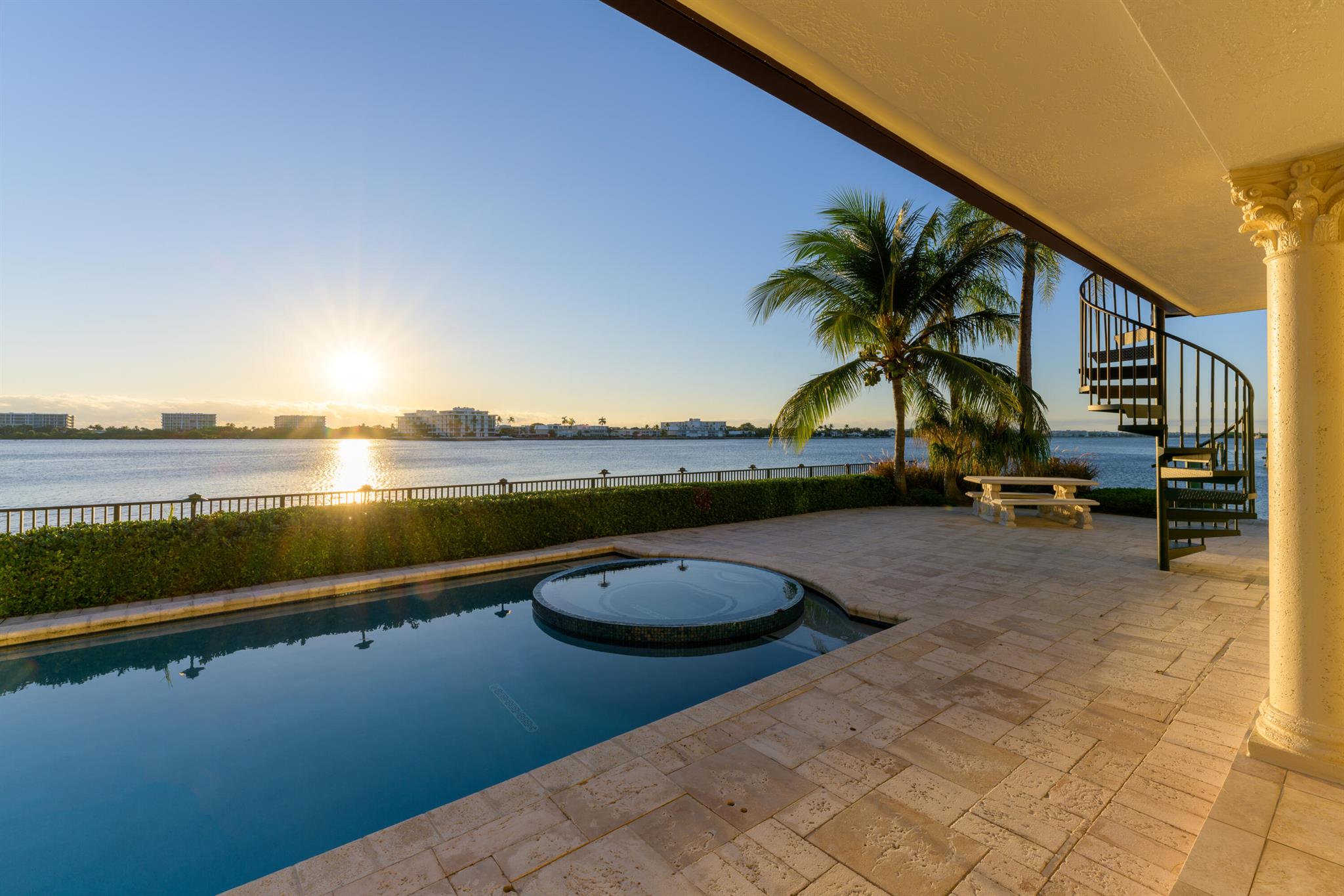 Awake to breathtaking sunrises while enjoying sun-bathed living spaces offered by this waterfront estate with coveted unobstructed East and Southeast vistas across wide water affording unparalleled security and privacy. Merely 15 min. from downtown West Palm and Palm Beach this residence is an entertainers delight. Highlights include a two story great room, an expansive kitchen with a 17 ft quartzite stone island, dining room with southeastern water views, waterfront loggias, an outdoor kitchen overlooking the Intracoastal, and an ocean facing rooftop terrace. Remarkable views & resort-style living await from the 5 bedroom primary suite with eastern & west balconies. Affording rare provision for a combination of vessels, this boaters paradise offers an upgraded seawall and a 125' dock.
