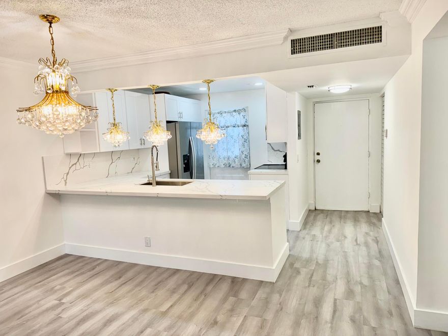 Welcome to this stunning, fully renovated 3-bedroom, 2-bathroom corner unit with an enclosed patio overlooking the heated community pool. No cost has been spared in this beautifully upgraded home, featuring luxury laminate flooring throughout and brand-new onyx tile in both bathrooms. The modern kitchen is highlighted by sophisticated designer chandeliers and flows seamlessly into the open-concept living and dining area—perfect for entertaining. Additional highlights include an in-unit washer and dryer, abundant natural light, and serene pool views. Move-in ready and ideally located near the beach, city amenities, and multiple universities. Water, cable, and internet are included in the rent.