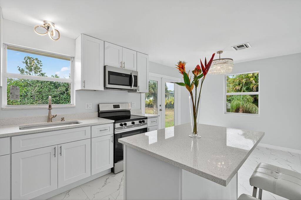Completely Renovated Jupiter Farms Home - No HOA, 1.25 Acres This beautifully renovated 3 bedroom, 2 bathroom home sits on a spacious 1.25 acre. Every detail has been thoughtfully curated, making it move-in ready. 2024 Roof, freshly painted in & out, exquisite new pavers at all entrances, New AC & Water Heater, New Impact Glass Windows & doors, Sophisticated Open concept Kitchen boasts custom Center Island, new Frigidaire appliances. Elegant living spaces, Modern Finishes & elegant bathrooms showcasing refined tile and marble. Tile and Porcelain Flooring throughout. GE washer & dryer. Room for pool/barn. On paved road, Top rated schools, 5 miles to I-95 & Florida Turnpike. This home combines modern upgrades with country style living, all within minutes of everything Jupiter has to offer