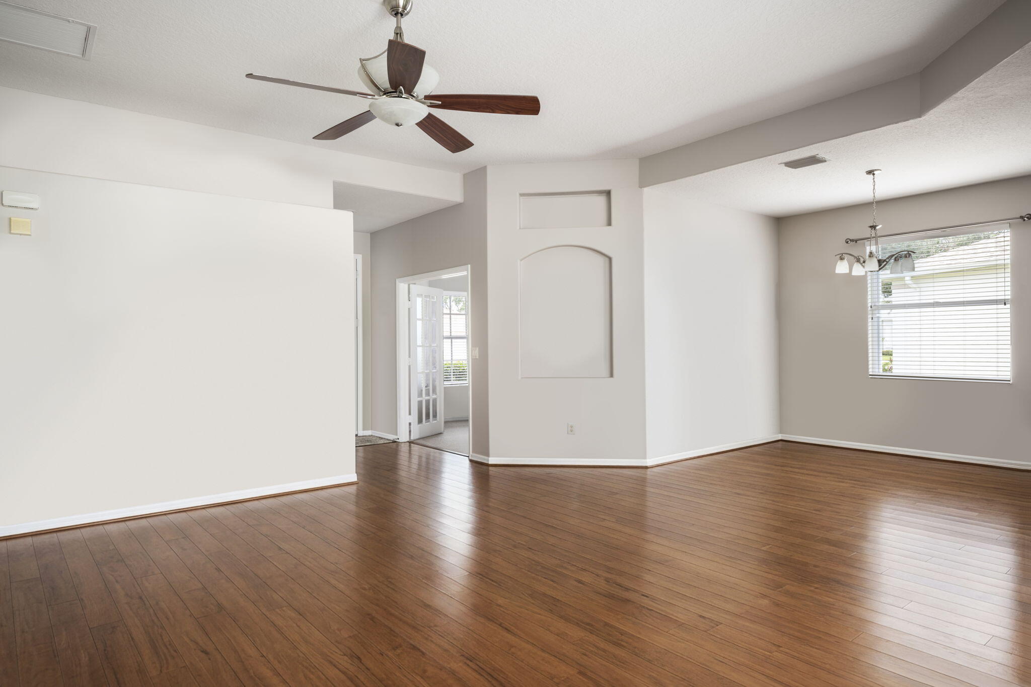 French doors opening to a versatile room featuring carpet flooring and neutral wall tones
