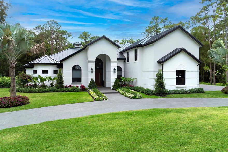 Set on 5 private acres in the heart of Loxahatchee, this stunning estate underwent a complete, top to bottom renovation completed in 2026 and shows like new construction throughout. With over 8,305 square feet of total living space, the property includes a 6 bedroom, 7 bathroom main residence with a 5 car garage, two home offices, plus a fully detached 2,116 square foot guest house, making it one of the most versatile and well appointed properties in the area. From the moment you arrive, the tone is set by a WiFi and Bluetooth equipped gate entry system framed by brand new professional landscaping that winds through a sweeping driveway leading to both the main home and the guest house beyond. Inside, soaring ceilings carry throughout every room. The gourmet kitchen is outfitted for the most discerning chef, anchored by a Wolf six burner double griddle gas range with double oven, a Sub-Zero refrigerator and freezer, and a Sub-Zero 80 bottle wine fridge with two refrigerated beverage drawers. The oversized island features a 42 inch galley sink with prep and entertaining accessories, a custom cutting board top, and a built in drawer microwave. The owners suite is conveniently located on the main floor and features a luxurious spa-like bathroom with separate shower.

The outdoor living spaces are equally impressive. The outdoor kitchen is built around a 32 inch Alfresco grill with a searing section and rotisserie, a Perlick beverage refrigerator, and a Perlick ice maker. A gas fire pit and mounted outdoor TV make the space ideal for entertaining year round, while a separate cabana with a full bathroom adds convenience right at the pool. The pool area itself is wired with a full audio system featuring two subwoofers and eight speakers, setting the stage for everything from casual afternoons to large gatherings.

Additional highlights include a full home reverse osmosis water system, a whole house standby generator powered by a new 1,000 gallon propane tank, a complete security system, a new Sonos whole home audio system with Bluetooth and WiFi, all new electrical and plumbing, a brand new pool, new rear patio deck, a new metal roof, and complete impact windows and doors throughout.

Tucked privately at the rear of the property, the brand new guest house offers a generous living room, a king bedroom with a full bath and washer and dryer, and a kitchenette. Step outside through the slider doors to a covered patio overlooking your own private pond with fountain, a peaceful retreat within the estate.

With 5 open acres, this property is ideally suited for equestrian use with ample room to build a barn and stalls. Built by a contractor owner with superior craftsmanship and no expense spared, this estate represents a rare combination of scale, quality, and privacy that is nearly impossible to find at this price point.