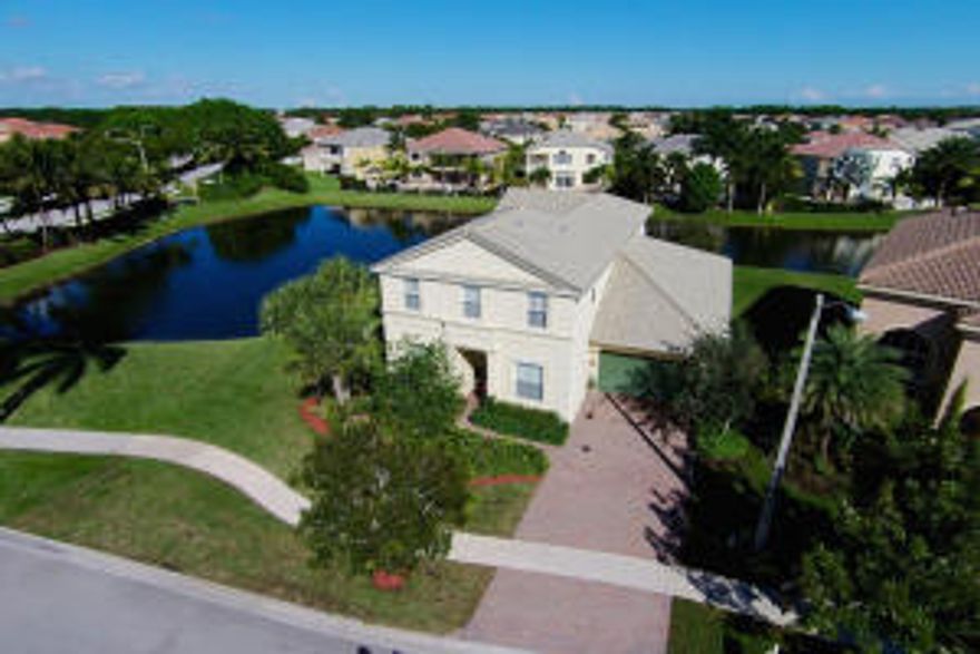 Highly desirable Terrasol floor plan with an in-law suite downstairs, 4 car garage,  and a unique waterfront lot with wrap around water views... This beautiful home is spacious and provides all the desirable upgrades and finishes one would expect... Gorgeous crown molding, hardwood flooring on the staircase and upstairs, quality tile flooring downstairs, butler's pantry, arched entries, lovely window treatments and the list goes on and on... The gourmet kitchen is model perfect and offers beautiful granite counter tops and back splash, upgraded cabinetry, stainless steel appliances and a spacious breakfast cafe... Other rooms includes a formal dining room, family room, formal sitting room, office (downstairs), and gaming loft upstairs... The master suite is large and offers a vaulted...... ceilings, private balcony, his and her walk-in closets... The master bathroom is fit for royalty with a large jetted soaking tub, dual sinks, separate shower and water closet...  Other notable upgrades include Brazilian Cherry Hardwood flooring, recessed lighting, volume ceilings, quality lighting fixtures and ceiling fans.... Don't settle for less... This beautiful home is ready now and will provide the ideal Florida lifestyle.  Olympia is a wonderful gated community with resort style amenities... The grand clubhouse offers a great room, catering kitchen, fitness center, indoor basketball court, teen room, card/meeting room and a spacious loggia. Outdoor amenities include a lagoon style pool with poolside cabanas, water park, playground, 4 lighted tennis courts, basketball and volleyball. The location is ideal an only minutes to A-rated Wellington schools, world class equestrian venues, the Wellington Green Mall,  Whole Foods, Trader Joe's, Fresh Market, restaurants and more... The Atlantic Ocean and the island of Palm Beach are only 12 miles away...