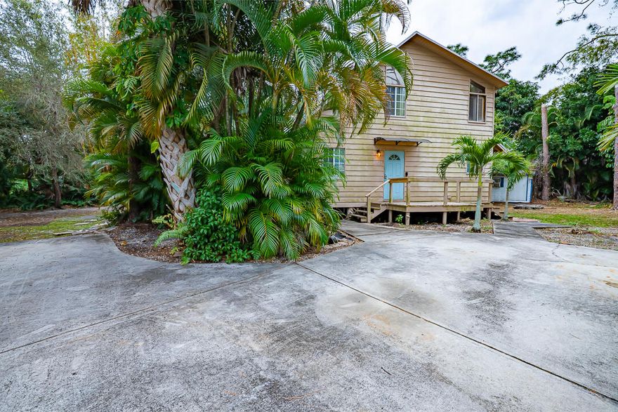 Tucked away on an oversized, secluded lot near Savannas State Park, this inviting 3-bedroom home offers privacy, charm, and room to live comfortably. The lush tropical landscape provides a serene setting and includes a storage shed. Double French doors open to spacious porches, ideal for entertaining or enjoying peaceful mornings outdoors. The kitchen features oak cabinetry, Corian and granite-trimmed countertops, a built-in Corian sink set beneath a bay window, and GE Profile stainless steel appliances. Interior highlights include hardwood floors, cedar ceilings, plantation shutters, palm blade paddle fans, and bamboo chair rail accents. A new 2023 driveway adds curb appeal. Located in Indian River Estates, this home blends character, space, and Florida tranquility.