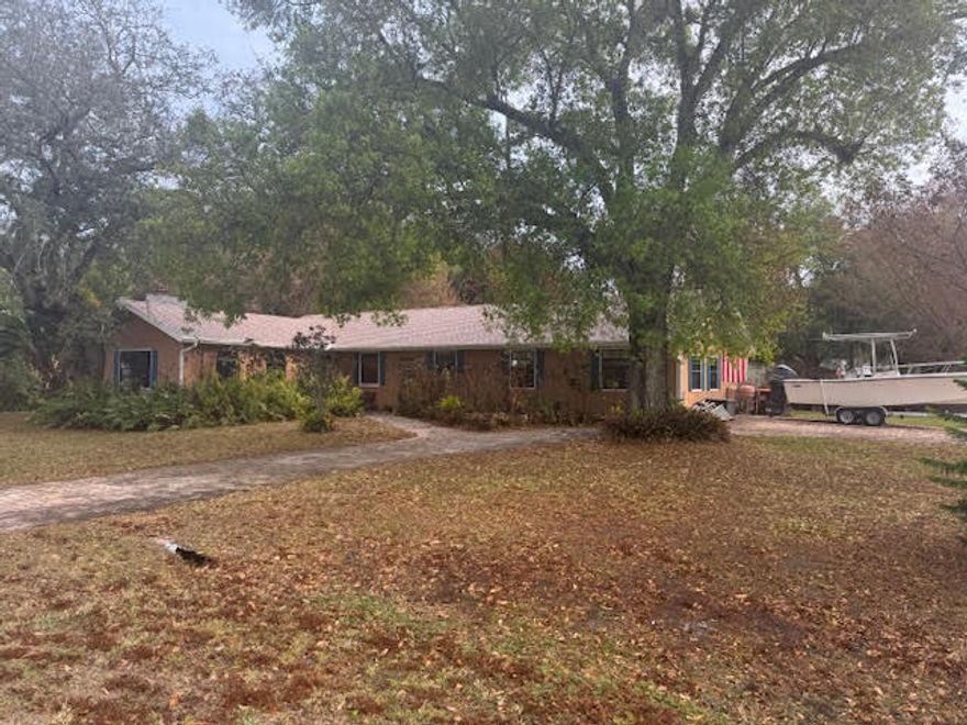 Beautifully maintained home on an oversized .45-acre double corner lot surrounded by canopied mature oak trees that offers curb appeal character & charm in a sought after non deed restricted neighborhood. New roof in May 2025 A/C 2023 paver stone circle driveway Kitchen opens to the dining room & family room. Separate living room features vaulted exposed wood beam ceilings & a working brick fireplace. The enclosed A/C Florida room has double French doors that lead to outside porch W/fully fenced yard an outdoor retreat complete with a he/she shed for extra storage W/power minutes to everything