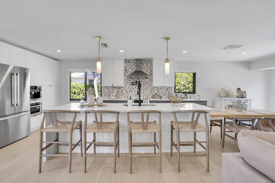 Welcome to Chapel Hill—one of East Boynton Beach's most sought-after neighborhoods—where this fully reimagined 3-bedroom, 3-bathroom pool home delivers the perfect blend of modern luxury and coastal lifestyle. Ideally located just minutes from the beach and the vibrant energy of Atlantic Avenue, this residence offers both convenience and refined living.  Completely renovated in 2022 by Emerald Isle Home Builders, the home showcases a thoughtfully designed open-concept layout with premium finishes throughout. Waterproof engineered wood flooring flows seamlessly across the living spaces, complemented by custom European-style cabinetry, quartz countertops, and a striking marble backsplash in the chef's kitchen. High-end appliances, including a Bosch suite and built-in Miele coffee system, elevate both function and design.  Each of the three full bathrooms has been meticulously curated with natural stone finishes, LED-lit mirrors, and bespoke cabinetry, creating a spa-like experience throughout. Expansive sliding glass doors flood the home with natural light and create a seamless indoor-outdoor connection.  Step outside to a private tropical retreat featuring a newly resurfaced, quartzite-lined pool and travertine pool deck—perfect for South Florida living.  Additional highlights include full smart home readiness with a built-in audio system, installed camera system, electric blinds, impact windows and doors, new plumbing and electrical systems, updated HVAC, and a newer roof—all providing peace of mind and true turnkey ownership.  This is a rare opportunity to own a fully renovated, move-in-ready home in Chapel Hill—where luxury, location, and lifestyle align.