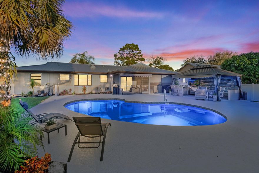 Are you searching for the perfect pool home in Port St. Lucie? This one deserves your attention. This 2 bed, 2 bath, 1154 sqft home offers a 2-car garage, a 2023 metal roof, & a saltwater pool with a covered bar, ideal for enjoying the Florida lifestyle.  The home has been thoughtfully updated & is move-in ready. The entire pool was resurfaced and updated with a new salt system  & equipment. The backyard was re-graded and enclosed with a new 8 ft PVC fence. Outdoor living is enhanced with a covered gazebo/bar/TV area, custom patio shades, & awnings blocking out the sun. New flooring and paint throughout. This smart-home is enabled with voice-controlled, a smart thermostat, &  smart door lock. Prime location close to shopping, restaurants, award-winning healthcare, and quick access to I95