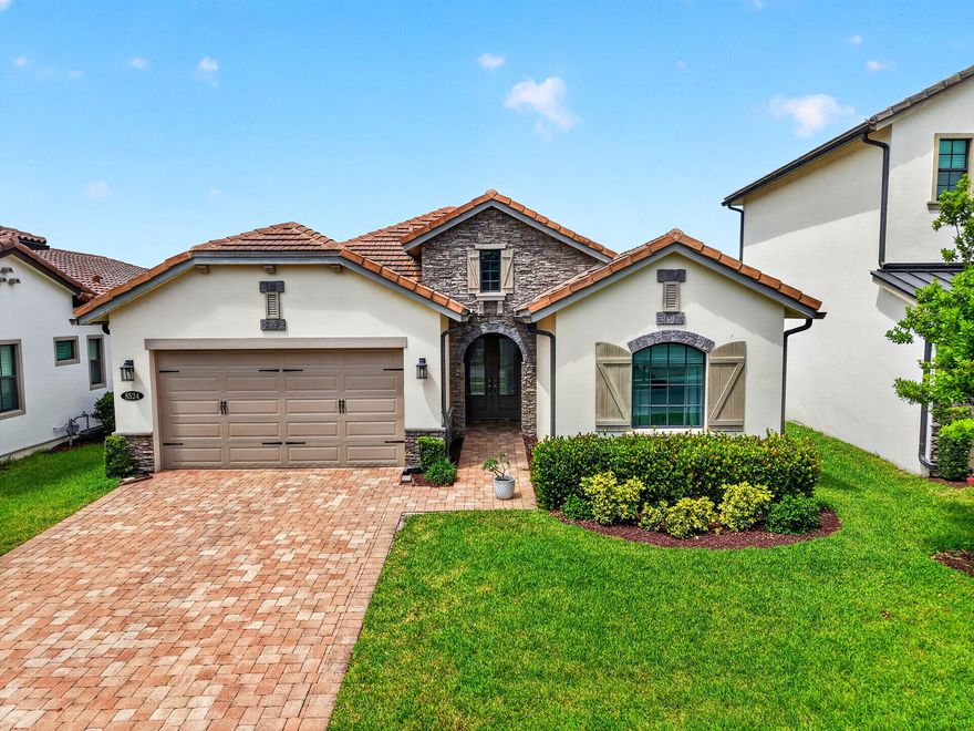 Built in 2018 within a gated community, this single-story home blends style and function. Enjoy a fenced yard and an oversized pavered, screened patio—perfect for outdoor living. Inside features 25" tile throughout and striking glass double front doors. The chef's kitchen offers two-tone cabinetry with glass accents, granite and quartz counters, subway backsplash, soft-close drawers, a 5-burner gas stove, double oven, and hidden pantry. The primary suite boasts dual sinks, two closets, a soaking tub, separate shower, and floor-to-ceiling tile and mirrors. Amenities include pool, kids splash zone, pickelball, tennis, indoor sport court, tot lot and fitness center. Impact glass, epoxy garage with EV charger, mud room, and laundry tub complete this stunning home.