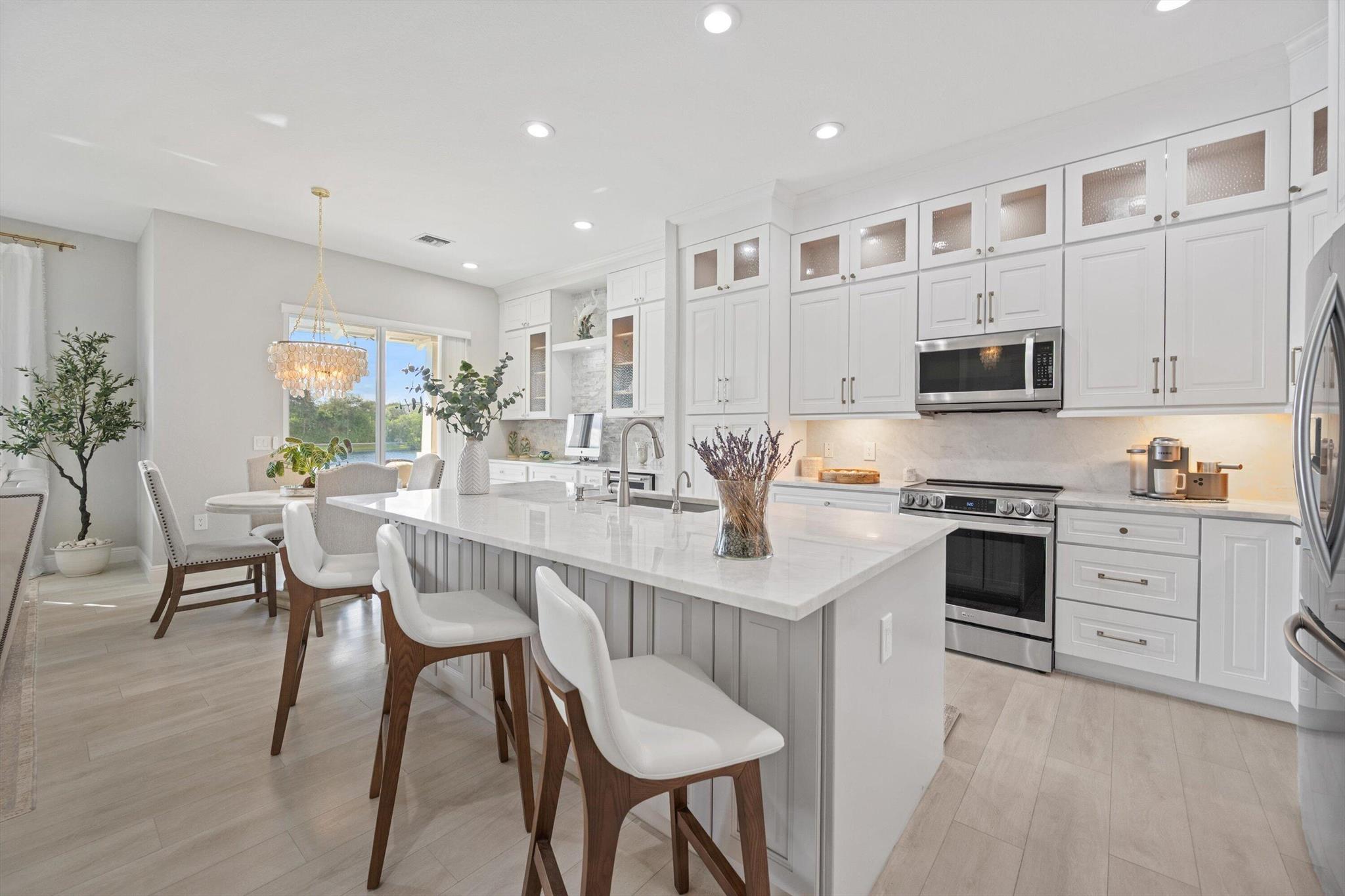 Welcome In To This Rare Find!! Most Desirable Lakefront 1 story (no stairs) Unit That Has Been Beautifully Updated, Opened Up & Completely Redesigned & Renovated. This Corner Unit Offers A Private Walkway & Entrance Into The Home. The Incredible Open Concept Kitchen Has High-End Cabinets Extending All The Way To The Ceiling & Expanding Over To A Thoughtfully Designed Desk/Office Space Along With Luxurious Stone Backsplash & Wine Fridge. The Stunning Kitchen Island & Countertops Have Upgraded Granite That Also Extend As A Backsplash Along With Stainless Steel Appliances. Coastal Chandeliers Adorn The Entryway Of The Front Door & Dining Room. Recessed Lighting Throughout.  Gorgeous Laminate Flooring Throughout The Main Living Areas & Bedrooms.