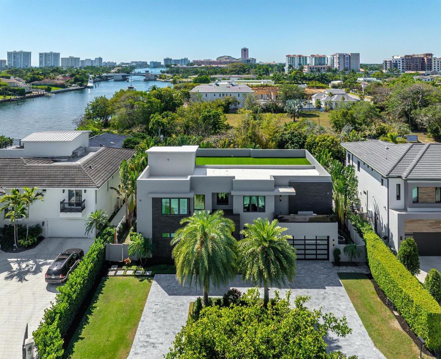 Tucked away on the smallest, most private cul-de-sac in Golden Triangle, a dramatic three story contemporary ultra custom residence is right beside Boca Raton's downtown intracoastal waterway. The sleek, modern facade captivates with bold geometric lines, floor-to-ceiling glass windows, a striking mix of smooth stucco and textured stone accents. The grand entrance, framed by custom glass doors and dark stone cladding, sets the stage for the exquisite interiors .Walking distance to the ocean and downtown Boca. East of NE 5th Ave the main house features a two story great room, open kitchen featuring Sub-Zero and Wolf, MAIN floor primary suite and full en-suite bedroom. The second level features three ensuite bedrooms (one currently used as a loft) a full theater, exercise room and office.