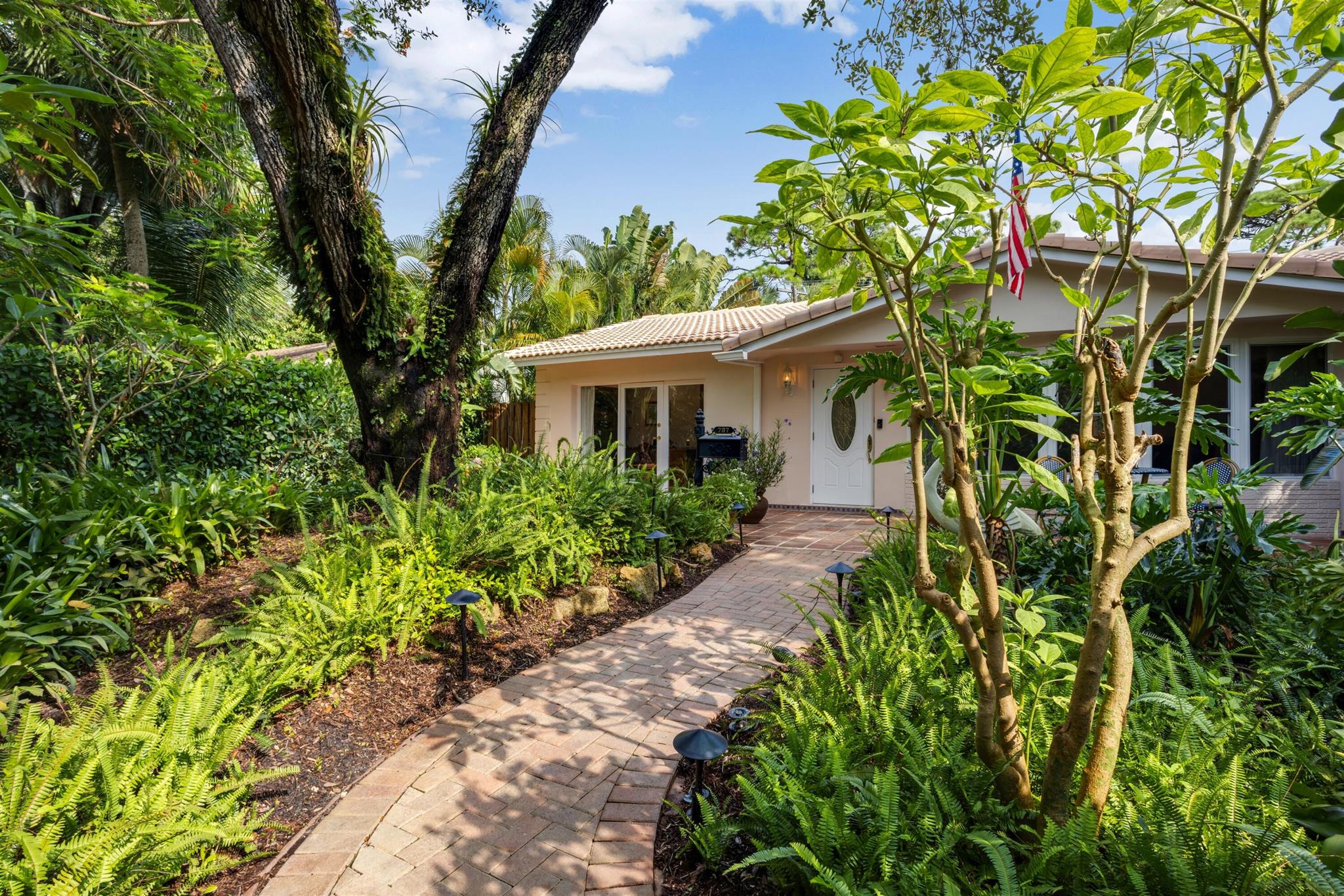 In an exquisite setting and radiating the charm of its era, this beautifully maintained residence is ideal for embracing South Florida's coveted lifestyle. With three bedrooms and 2,408+/- total square feet, its well-conceived floor plan was designed to optimize garden and pool views, seamlessly blending indoor and outdoor spaces. Details throughout include skylights making the interiors light and bright, custom built-in cabinetry, handsome moldings and clay-tile flooring. In the living room, a bay window overlooks the front gardens, while a fireplace adds a welcoming cordiality. The dining area comprises two areas, both defined by skylights and featuring French doors accessing the pool terrace. Just adjacent, the kitchen is fitted with cerused-wood cabinetry, mirrored backsplashes and a p