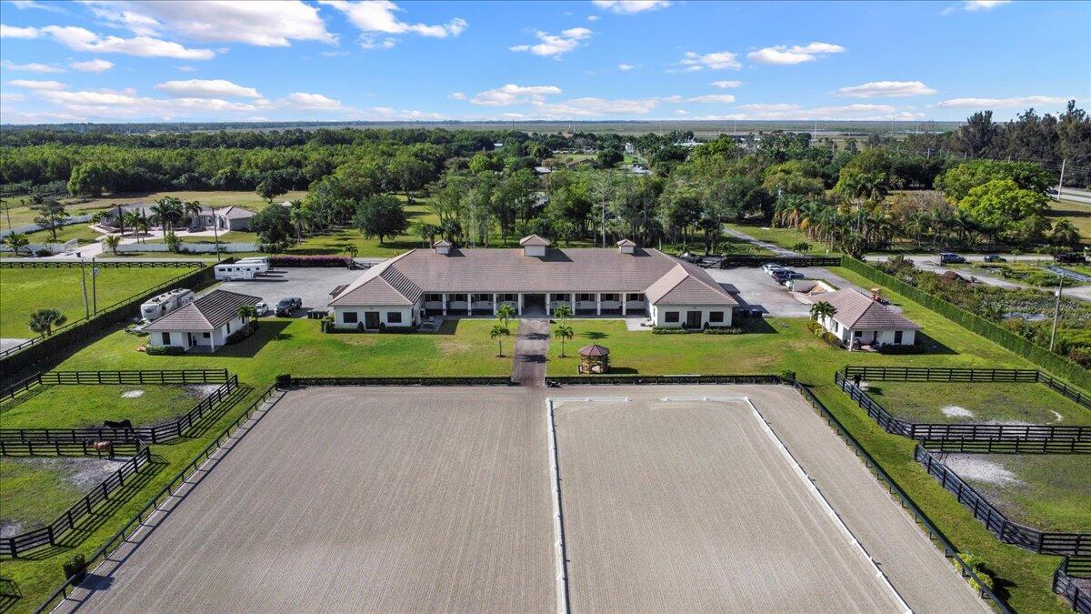 Located just a short drive to Wellington's horse showgrounds, this luxurious barn, built in 2017, is available for rent and is in impeccable condition. Situated conveniently on a paved road, the property offers 4 to 8+ stalls, shared access to premium amenities including an air-conditioned tack room, feed room, laundry facilities, a half bath, wash racks and 8 paddocks. The property is fully fenced with an automatic gate for security and ease of access, ample parking and shared use of a generously sized arena (250' x 180') with a covered viewing area. Additionally, this remarkable property also has 2 camper hookup spots for added convenience. Surrounded by gorgeous palm trees and lush landscaping, the barn offers a picturesque ambiance. The landlord will accept Dressage or H/J tenants.