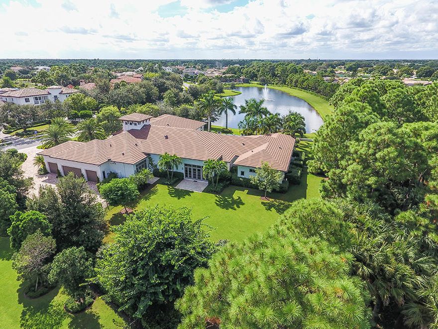 This impeccable single story, 5 bedroom, custom estate is ideally situated on more than one acre of meticulously landscaped grounds with beautiful lake, fountain and preserve views. This residence features a stunning Downsview Kitchen with expansive island, breakfast bar and wine storage. French doors and glass sliders lead out to one of the largest yard spaces and a covered loggia, ideal for entertaining and relaxation. The outdoor space includes an expansive patio and infinity edge pool which is transformed at night by custom lighting and fire pots. The home theater with luxury seating and club room with custom built-ins are additional features that complete the space of this stunning Old Palm estate.