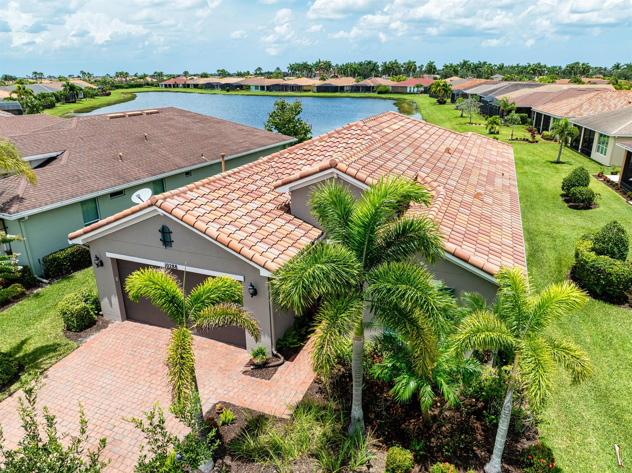 This beautifully maintained 2 bedroom, 2 bathroom home with a versatile den offers over 2,000 square feet of comfortable living space and thoughtful upgrades throughout. Built for efficiency and durability, the home features aftermarket impact windows (installed in 2018), core fill block insulation, blown attic insulation, and custom Hunter Douglas window treatments paired with elegant plantation shutters. The spacious open floor plan includes a bright family room that flows seamlessly into the dining area and a gourmet kitchen complete with 42-inch cabinets, granite countertops, and a direct view of the living space--perfect for entertaining. Step outside to an oversized covered, extended lanai with ''tiny mesh'' extra tight screening that showcases a stunning lake view,