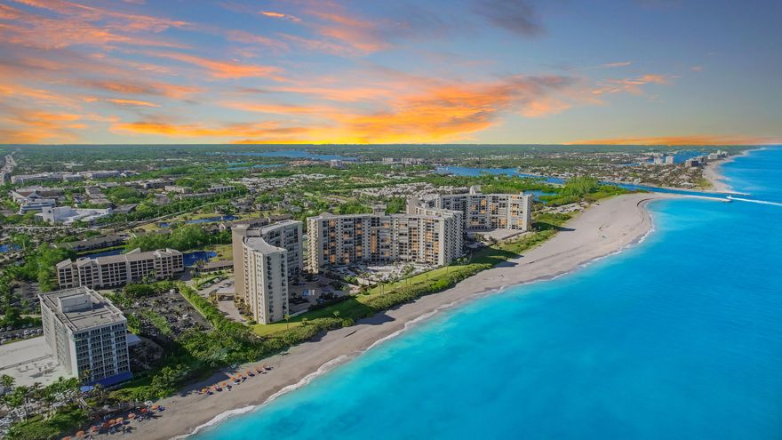 Experience resort-style beachfront living in this stunning fully updated 2-bedroom, 2-bath luxury oceanfront condo featuring a desirable split floor plan and breathtaking ocean views from every room. The expansive balcony, accessible from both the owner's suite and living area, offers ample seating space to relax and enjoy the wide water and beachfront views. The chef's kitchen is beautifully appointed with stainless steel GE Profile appliances including a convection oven, granite countertops, maple cabinetry with soft-close drawers, pantry cabinet with roll-out shelving, Lazy Susan, baking rack storage, and breakfast bar seating. Spacious living areas are enhanced with pocket doors to maximize functionality and flow. Luxurious bathrooms feature waterfall shower systems... granite counters and maple cabinetry. Decorated in neutral tones and meticulously updated throughout, this residence is absolutely turnkey and move-in ready. Complete with covered assigned private parking, this exceptional condo truly feels like a private oceanfront resort oasis.  Ocean Trails is an oceanfront community that sits directly on the sand and offers resort-style amenities including gated entry, heated pools, tennis courts, pickleball, fitness center, clubhouse, beach access, underground parking, and beautifully maintained grounds. This premier Jupiter location is just moments from the Jupiter Inlet, waterfront dining, shopping, golf, and Harbourside. Ideal for full-time and seasonal residents seeking luxury beachfront living
