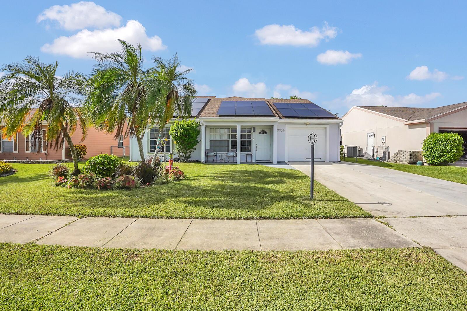 Experience the perfect blend of comfort and efficiency in this delightful single-family home, nestled within the charming Countrywood community in Lake Worth, FL. Equipped with a spacious 850 sq ft mother-in-law suite offering complete privacy with its own exterior entrance. It boasts a spacious living room, full bathroom, large bedroom with walk-in closet, and a private back patio overlooking tranquil canal views perfect for extended family or guests. Upon entering the residence you are greeted with vaulted ceilings immediately enhancing the sense of space and light. The thoughtfully combined living and dining area provides an open and inviting atmosphere, ideal for both daily relaxation and entertaining.