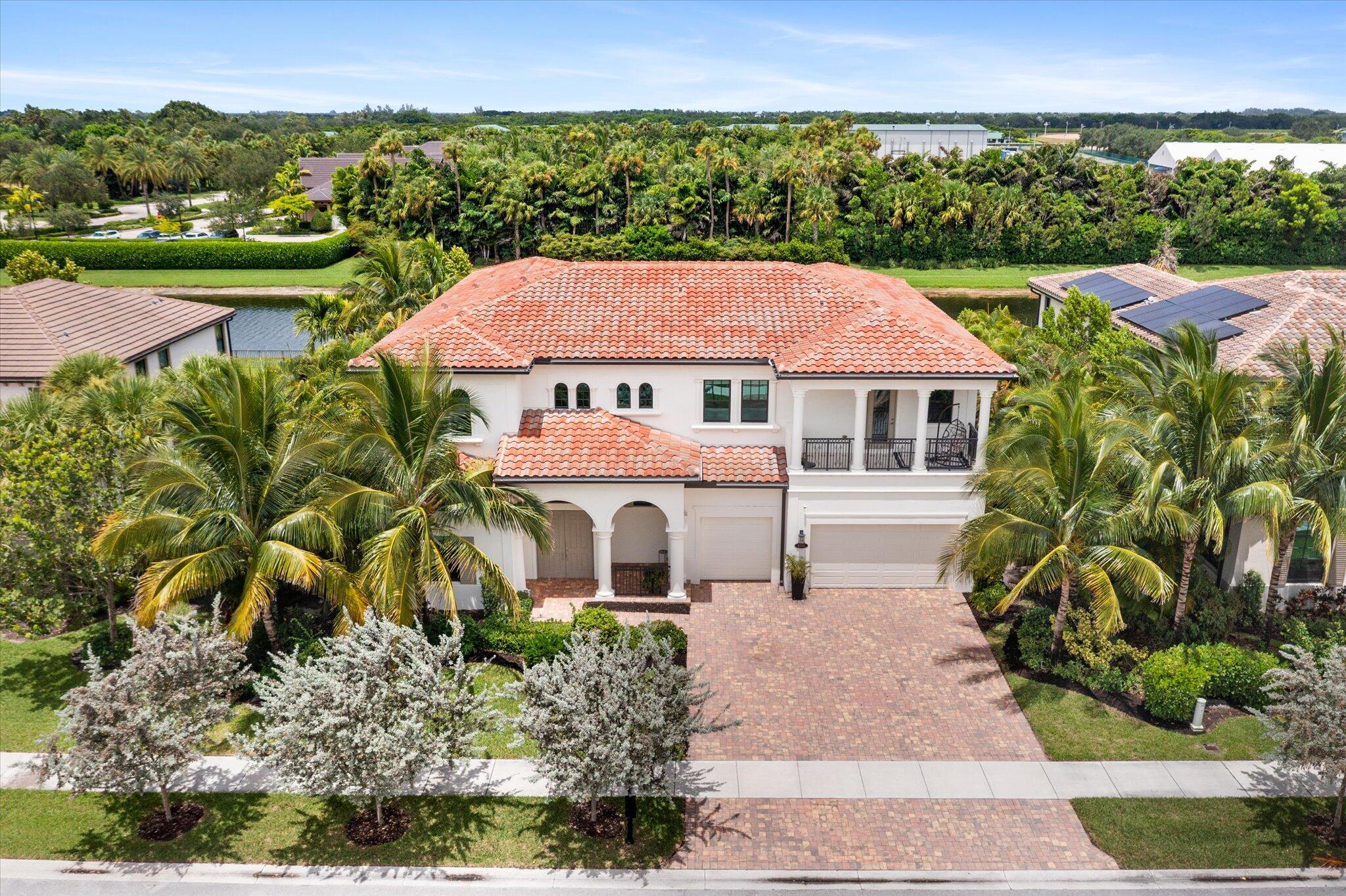 Waterfront Serenity Meets Equestrian Prestige | Adjacent to Lush Stables & Racetrack, Minutes From Wellington Equestrian Center | Breathtaking Panoramic Lake Views | Hurricane Impact Windows & Doors | Open Layout w/ Soaring Ceilings | Crown Molding, Accent Details & Designer Fixtures | Grand Foyer w/ Dramatic Winding Staircase | Gourmet Kitchen Featuring Quartz Counters, Soft-Close Cabinetry, High-End Stainless Appliances, Island Seating & Dual Butler's Pantries | Lavish Primary Suite w/ Walk-In Closets | Spa-Inspired Bath w/ Soaking Tub, Frameless Rain Shower & Separate Vanities | Four Guest Suites w/ Ensuite Baths -- Two w/ Private Balconies | Cabana Bath | Covered Patio & Expansive Backyard | Resort Style Amenities: Clubhouse, Pool & Spa, Fitness Center, Sports Courts, Kids Area & More!