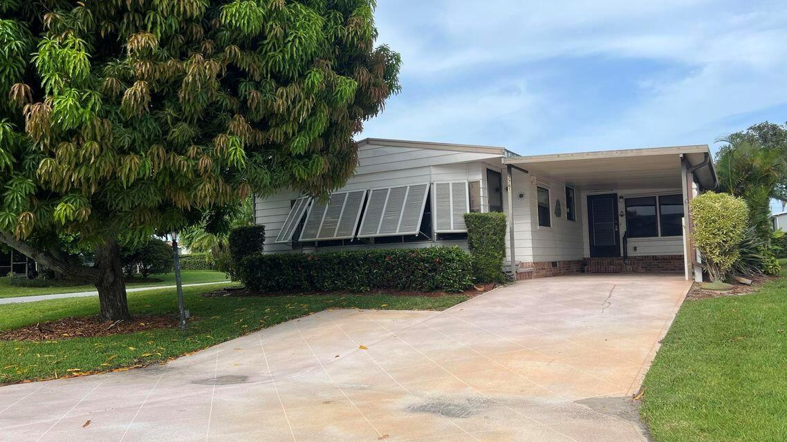 **Oversized Corner Location!** This spacious 2-bedroom, 2-bath Palm Harbor manufactured home is situated in the Cambridge 55+ community in Hobe Sound. Enjoy the added benefit of having your own large mango tree! This home is perfect for entertaining, featuring a side Florida room that is air-conditioned and on the same level as the main living area. The kitchen is open to the family room and includes a wet bar, creating a great flow to the living and dining areas. This design is one of the most popular floor plans! The master bedroom is generously sized and features a bay window, along with an ensuite bath that boasts a step-in shower, dual sinks, and a soaking tub. The second bedroom has an adjoining bath with a tub/shower combo.