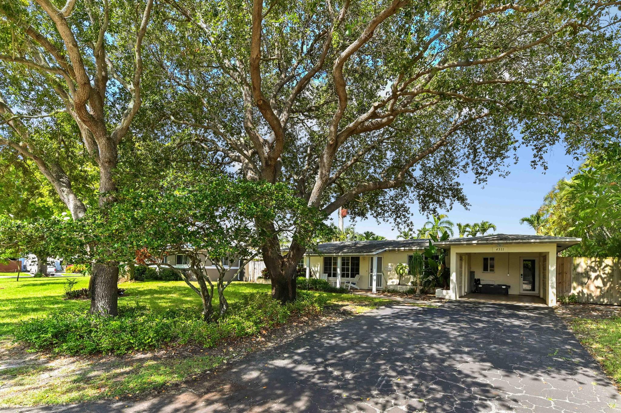 This charming 1-story pool home offers 3 beds, 2 baths and 1,586 sq ft of comfortable living space. Enjoy peace of mind with hurricane impact windows and a 1-car carport attached. Inside, you'll find classic terrazzo flooring throughout and a spacious kitchen featuring granite countertops, a gas stove, ample cabinet storage, and appliances included. A bright kitchen window provides a lovely view of the pool area, making meal prep a delight.