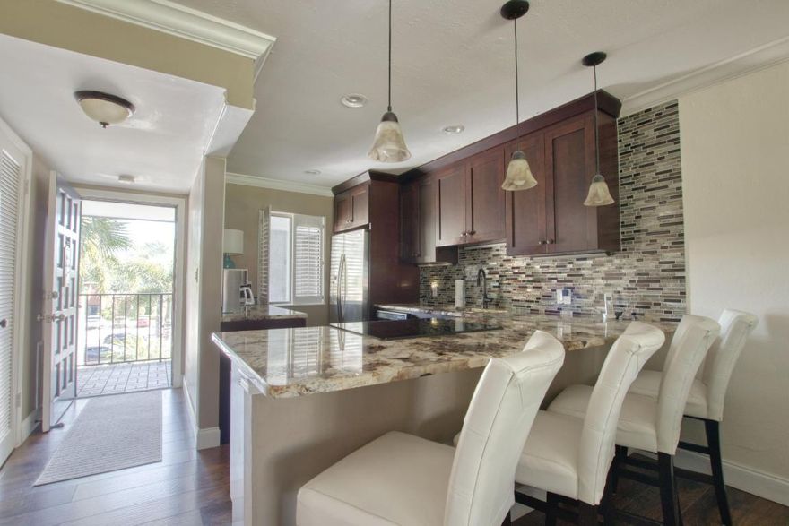 Uniquely renovated 2/2 condo exposing eye catching oversized granite counter tops the minute you walk in.  The kitchen wall is down drawing in natural sunlight & warm ambiance, Enjoy walk in closet, washer/dryer/ new AC, crown molding, laminate flooring in the living area & beautiful, screened balcony to enjoy your morning coffee.  This home is coming turnkey with designer furnishings.  Your tropical community pool/spa is right out your front door w. this amazing location.  Experience the peace & security of manned guard gates & 24-hour security patrols all located on lush, tropical gardens.  You are minutes from Fla. Turnpike, I 95, great restaurants, entertainment, shopping, airports, medical centers, places of worship, Polo Grounds, WPB, Delray Beach, & our beautiful beaches.