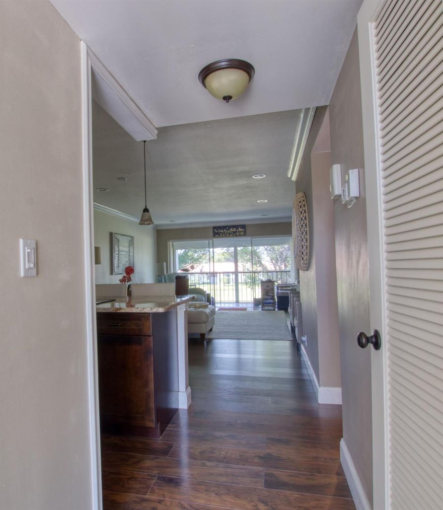 Uniquely renovated 2/2 condo exposing eye catching oversized granite counter tops the minute you walk in.  The kitchen wall is down drawing in natural sunlight & warm ambiance, Enjoy walk in closet, washer/dryer/ new AC, crown molding, laminate flooring in the living area & beautiful, screened balcony to enjoy your morning coffee.  This home is coming turnkey with designer furnishings.  Your tropical community pool/spa is right out your front door w. this amazing location.  Experience the peace & security of manned guard gates & 24-hour security patrols all located on lush, tropical gardens.  You are minutes from Fla. Turnpike, I 95, great restaurants, entertainment, shopping, airports, medical centers, places of worship, Polo Grounds, WPB, Delray Beach, & our beautiful beaches.