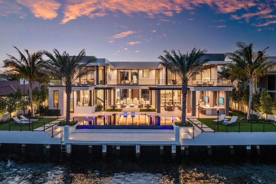 Experience a new pinnacle of luxury in this recently completed, turn-key Signature Estate by SRD Building Corp, redefining elite Intracoastal living. Just completed, this impressive residence is located on a prime lot within the exclusive Royal Palm Yacht & Country Club in Boca Raton. Spanning over 8,500 square feet, this six-bedroom estate boasts 100 feet of Intracoastal frontage with coveted eastern exposure and a 4-car plus golf cart garage. <MORE> Every element of this home is crafted for ultimate refinement, from the fully automated Crestron smart-home system to the state-of-the-art security features. The primary suite offers stunning Intracoastal views and separate His & Her spa-like bathrooms for a retreat of pure indulgence. Entertain effortlessly in the sleek clubroom, featuring a bar, billiards area, and a stunning glass wine room, or prepare culinary delights in the chef's kitchen with an inviting eat-in dining space.

The outdoor experience is unparalleled, with a resort-style backyard featuring a knife-edge pool and spa, bordered by premium turf and ambient fire features. Fully retractable screens allow for seamless indoor-outdoor living, providing year-round enjoyment in every space. Furnished by the award-winning P&H Interiors design group, this waterfront masterpiece is ready to offer an extraordinary lifestyle. The buyer is responsible for documentary stamp taxes on the deed and title insurance.