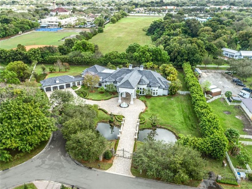 ONE-OF-A-KIND MODERN FRENCH COUNTRY HOME... PREMIERE TROPHY RESIDENCE POSITIONED ON 2.43 ACRES IN SUNSHINE RANCHES AT WITHIN BEAUTIFUL STONECREEK!!! STORY-BOOK SETTING NESTLED ON THE AMAZING CUL-DE-SAC W/A REMARKABLE BRIDGE & POND. FORTIFIED W/COLUMNS, CUSTOM FENCING & TWO ELECTRONIC IRON GATES. ARCHITECTUALLY PLEASING TO THE EYE, THIS INCOMPARABLE HOME OFFERS 7 BEDROOMS, 8 FULL BATHS, 2 HALF BATHS, 4 CAR GARAGE, 2 CAR PORTE CACHERE W/ OVER 12,000 SF OF TOTAL LUXURY. IMPRESSIVE CEILINGS W/DECORATIVE ARCHWAY AND COLUMNS. GOURMET KITCHEN, BRAND NEW QUARTZ COUNTERS, TOP OF THE LINE APPLIANCE PACKAGE, HOME THEATER, OFFICE W/CUSTOM BUILT-INS & GYM/PLAYROOM, FULL BAR. VERANDA, BRAND NEW SUMMER KITCHEN, RESORT STYLE POOL W/BEACH ENTRY. ONLY COMMUNITY WITH CITY WATER/CITY SEWER.