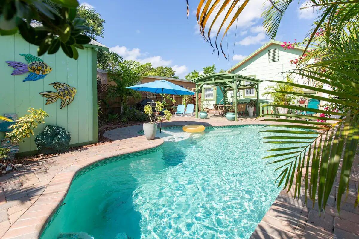 Charming Lake Worth Beach home with detached cottage and saltwater pool in Mango Groves Historic District! Just east of Dixie Hwy, 7 blocks from downtown and under a mile to the beach. Main house has 2 beds, 1 bath, bamboo floors, new bedroom carpet, formal dining, hurricane windows, and a stylish kitchen with Silestone counters, stainless appliances, and glass tile backsplash. Enjoy a free-form saltwater pool, brick patio, lush landscaping, and a guest cottage with bath, A/C, and kitchenette.