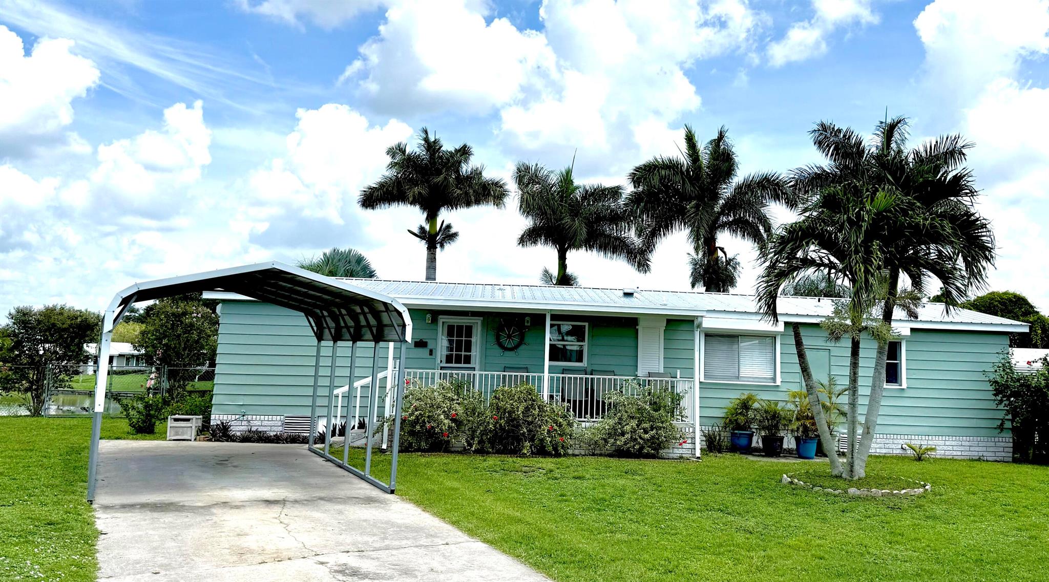 Taylor Creek Isles-Lake O & Ocean Access! Pristine waterfront beauty on ''The Point'' exclusively surrounded by three sides of navigable water. Renovated and comes partially furnished! 2bed/2bath DWMH on .36 acre. Interior laundry, screened outdoor living space & BBQ area, adorned with Foxtail Palms, Silver Bismark, & tropical flowers. Dock, fish cleaning table, Concrete seawall. Hurricane crank down shutters! Enjoy VACATION everyday at home! This spacious home is versatile for large gatherings, family vacations, or open mobility throughout home. Double side gate, 2 Car Carport, 4 car driveway located on Cul-de-sac for boat turn around! Minutes from Lock and ramp. INCOME PRODUCING Airbnb that stays booked. Call Today before this is gone! Priced to sell. Appointment Required.