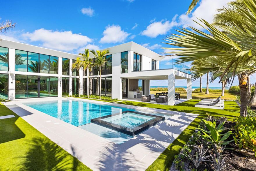 Discover the rare allure of a brand-new beachfront gem on the pristine shores of Jupiter Island. This stunning contemporary residence, with 6,500 square feet of meticulously crafted, air-conditioned living space, offers uninterrupted ocean views from every corner. Featuring five spacious bedrooms and five and a half elegantly appointed bathrooms, this concrete and steel constructed fortress is a true masterpiece of modern design. It seamlessly combines style with functionality, boasting floor-to-ceiling glass throughout that captures breathtaking views and fills the home with natural light. Created with the finest materials and exquisite finishes, this architectural marvel is the vision of the esteemed Affinity Architects, brought to life by one of the top local builder, Coastal Property