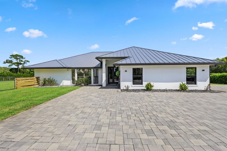 Available for season (or beyond) fully furnished! Welcome to your equestrian paradise in the prestigious community of Caloosa. This stunning property spans over 5 acres of serene landscape, which surround your 4 bed, 3 bath, completely renovated home. A brand new pool deck, summer kitchen, and outdoor fitness area highlight some of the many recent upgrades, and provide for an endless entertainment landscape. Outside, equestrians will delight in the brand-new barn, which can accommodate up to 10 horse stalls if desired. Currently, the property has 2 stalls already in place. The lush landscaping and majestic palm trees provide a picturesque setting for unmatched privacy. A newly installed roof and a grand, sweeping driveway add both practicality and charm to this exclusive retreat