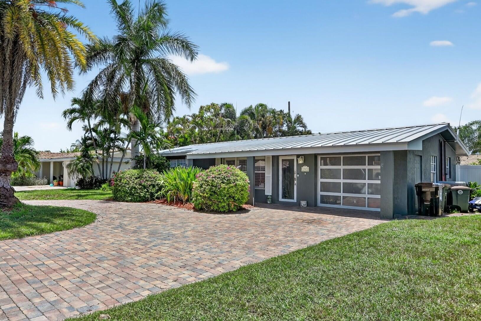 Discover your slice of paradise in highly sought-after Lighthouse Point! This 3-bedroom, 2-bath, pool home offers the perfect blend of comfort, style, and South Florida charm. Nestled on a quiet street in one of the area's most desirable neighborhoods, this residence is ideal for entertaining and enjoying the laid-back coastal lifestyle. Step inside to an open floor plan that flows seamlessly from the living area to the kitchen and out to the tropical backyard retreat. Enjoy a new metal roof (2024), two newer HVAC systems (2021), and top-of-the-line vinyl fencing that fully encloses the property for privacy. The backyard oasis features a sparkling L-shaped pool and a tiki hut--perfect for hosting friends and family year-round. Enjoy easy maintenance with artificial turf in the backyard.