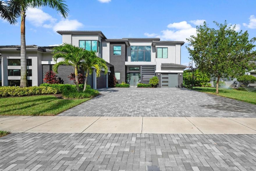 Experience unparalleled elegance and modern sophistication in this exceptional contemporary
Palermo home in one of Boca Raton's most coveted neighborhoods, Boca Bridges. A
masterpiece of contemporary luxury and design, this expansive 6,175 SF residence packed with upgrades and modern amenities sits on an approximately 1⁄3 acre private lakefront lot with no rear neighbors and single story homes on either side for added privacy. No detail overlooked, this desirable floor plan features a sleek elevator, 6 bedrooms, 8 and a half bathrooms, a loft/media/game room, two laundry rooms, and a four-car garage. As you enter the home, marvel at the exquisite custom millwork, the architectural beauty of the
glass staircase with oak wood steps, and the oversized industrial porcelain flooring that sets the stage for what's to come. Above, soaring ceilings showcase a magnificent handcrafted Restoration Hardware chandeliera round metal masterpiece with a brilliant crystal interior, conveniently maintained with an electric lift system for effortless cleaning and bulb replacement. Designed for the ultimate entertainer, this home features a spacious living room with a custom double-sided gas fireplace that opens seamlessly to the clubroom, enhancing the ambiance of both spaces. Expansive sliding glass doors from each room lead to the patio, inviting effortless indoor-outdoor living year-round. A stylish wet barcomplete with a sink and beverage refrigeratorserves as a perfect centerpiece for gatherings, designed to blend beauty and usability. Custom-made whiskey bottle pendants cast a warm glow over the bar, complemented by a stunning tile backsplash, enhancing the home's modern aesthetic.The gourmet eat-in kitchen is a stunning showcase of design and functionality, featuring dual islands topped with 3-inch quartz Caesarstone rugged concrete countertops and upgraded cabinetry with convenient pull-out drawers. A breathtaking professional-grade designer faucet serves as both a culinary tool and a work of art, beautifully complemented by Art Deco-inspired black and white pendants from renowned designer Louis Poulsen. This exceptional space is equipped with two Bosch dishwashers, dual side-by-side Sub-Zero refrigerators with four freezer drawers for effortless organization, a 48-inch Wolf gas range with six burners, a center grill, and double ovens, plus two additional wall ovens. A Wolf microwave, walk-in pantry, and sophisticated coffee bar complete this dream kitchencrafted for both elegance and performance.
Adjacent to the kitchen is the sun-drenched family room, which boasts expansive zero-entry sliders that extend the living space into the picturesque backyard retreat. Rounding out the first floor is a convenient cabana bath, a stylish powder room showcasing an impressive marble and gold accent wall by Artistic Tile, a private ensuite bedroom, and a thoughtfully designed sleek laundry room.
The primary suite is a sanctuary unto itself, featuring a morning bar, his and her bathrooms, a cozy fireplace, bespoke millwork, and a wrap-around balcony. The custom floor-to-ceiling dual
walk-in closets offer meticulously organized storage for every need. The spa-like bathroom is an owner's dream, showcasing a freestanding jacuzzi and an oversized glass-enclosed shower
connecting both bathroomsexpertly designed with dual body jets, an overhead rain shower, handheld, and an additional shower head for the ultimate experience. Three-inch Naxos quartz countertops and custom marble feature walls complete the space with timeless elegance. The backyard is as remarkable as the interior, boasting a custom extended pool with oversized jacuzzi, a sunshelf with lounge chairs, and a striking water featurecreating a breathtaking
retreat for relaxation and entertainment. Experience the essence of outdoor living with a fully equipped summer kitchen, elegant dining area, and inviting gas fire pit, perfect for gatherings under the stars.
This home is thoughtfully equipped with a full water purification system featuring reverse osmosis drinking water, a whole-house generator, and impact windows for enhanced safety and
peace of mind. Modern comforts abound, including Control4 smart home technology, upgraded lighting throughout, and a three-car air-conditioned garage with a Tesla wall connector, complemented by a separate single-car air-conditioned garage gym. Additional enhancements include an electric pool heater and a discreet toad fence for added security.A true masterpiece of design and innovation, this residence offers the pinnacle of modern luxury
living. Don't miss the opportunity to make it your own.