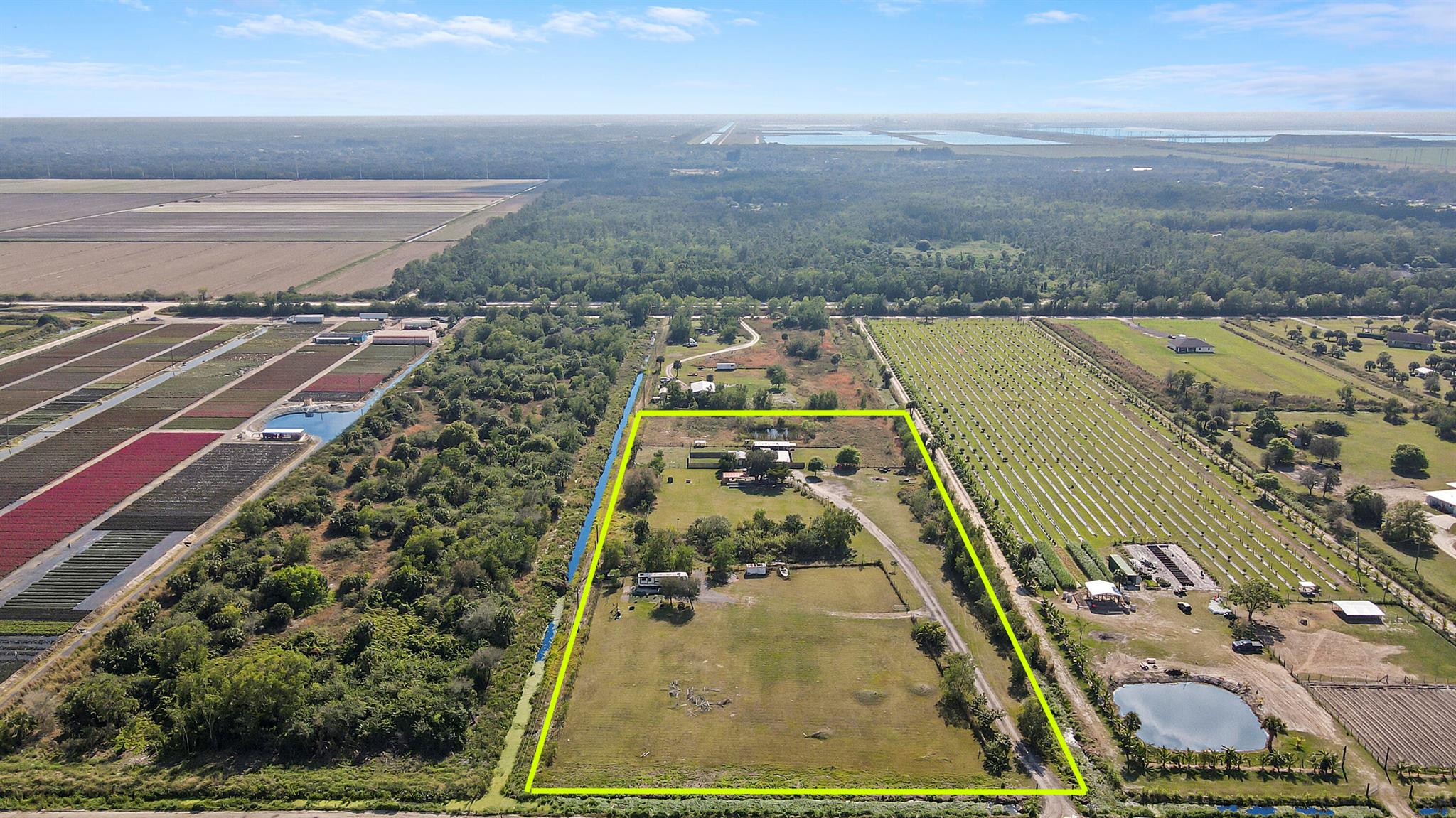 Discover the ultimate in versatility on this expansive property at 20230 Simone Drive, Loxahatchee, FL 33470. Just under 7 acres, this land offers a unique opportunity for a variety of uses. Currently serving as a dog training facility, the property includes two small office buildings, kennels, and a concrete carport. The leveled and sodded grounds provide a pristine backdrop for your vision. RV does not convey.