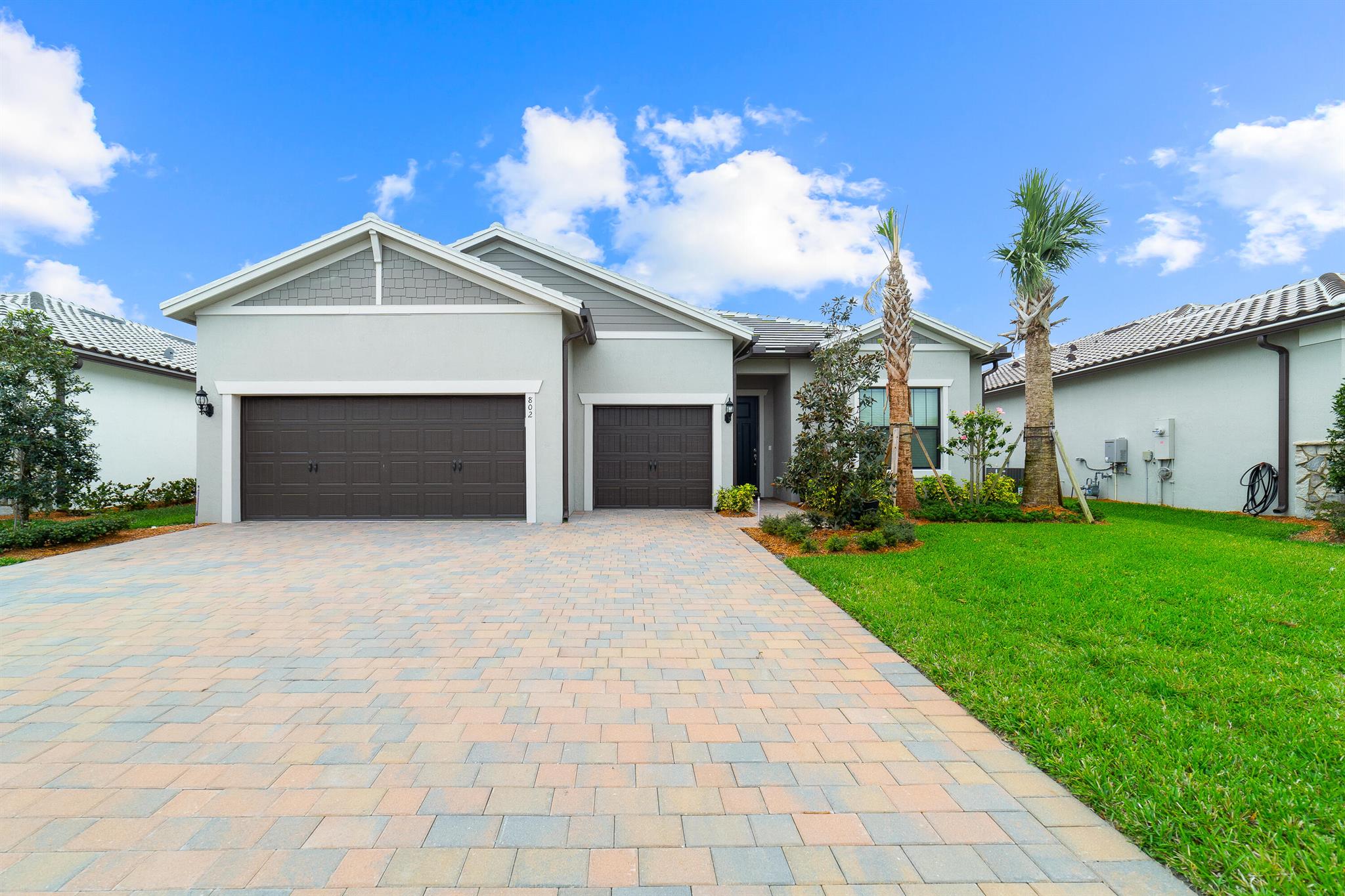 Welcome home to this immaculate like new 3 bedroom 2.5 bath + office/den 2023 Ashby Estate home in the highly sought after Veranda Gardens of Port St. Lucie. As soon as you enter, you immediately notice the soaring 10' ceilings and abundant natural light. The home features a split bedroom floor plan for convenience and privacy as well as Impact windows and doors. Tile flooring throughout the home offers a sleek modern appearance and design continuity. The kitchen boasts stainless steel KitchenAid appliances, gas cooktop, modern white cabinetry, quartz countertops and a huge center island with seating leading out into the family room, perfect for entertaining. The open concept allows for a welcoming feel and ease of use. The primary suite provides tons of space with water view, tray