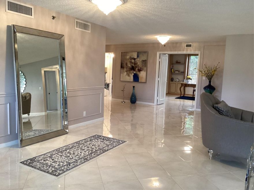 Custom-decorated 2nd-floor unit with neutral colors and two new A/C units (July 2024). Building re-roofed March 2024 and repainted Q4 2022. Beautifully updated interior with unobstructed golf & lake views.  Only 2 units per floor with semi-private elevator and under-building parking. Features beautiful and spacious kitchen & baths, custom wood paneling, solid doors, spectacular décor, custom lighting, huge glass-enclosed terrace, and stunning lake & golf views.  parking space #54,  Furnished cabana #12, and locker #1. Come experience elegance and comfort in this exceptional Boca Pointe condo.