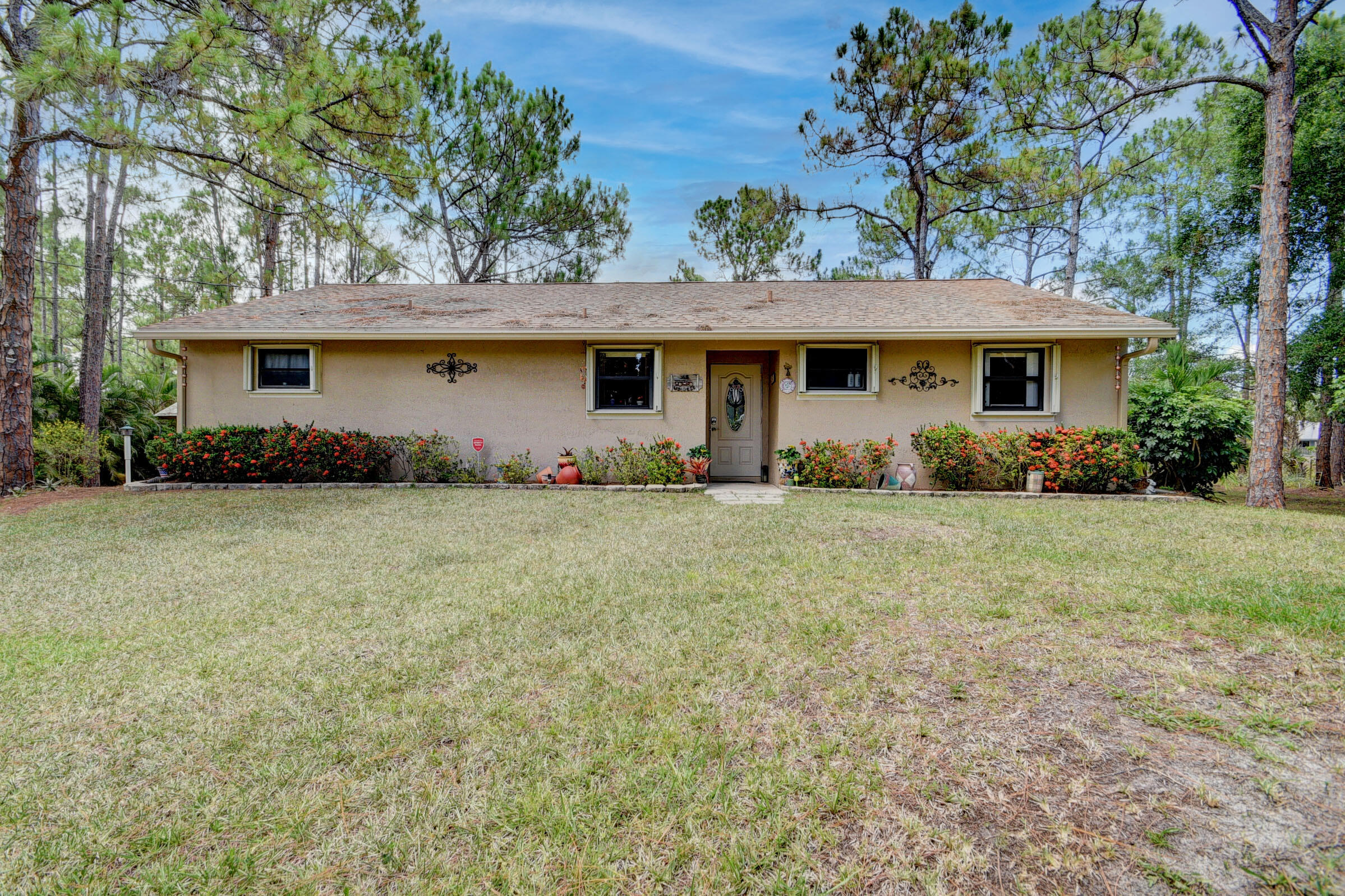 First time available....! Original owners selling this well maintained 3 Bed, 2 Bath home on 1.3 beautifully and natively landscaped acres. Large lot with mature trees provide serene setting for this home, canal along the back of the property provides extra privacy. Approximately 5 years ago updates include complete kitchen with granite tops, wood cabinets and new appliances, bathrooms, bedroom floors, crown molding, ceiling fans, new well and water system and home re-plumbed. Accordion shutters all the way around for simple hurricane protection. The property is completely fenced for your animals or the kids to play. Convenient to great schools, shopping and access to the Turnpike. Seller will need post occupancy until mid-September.