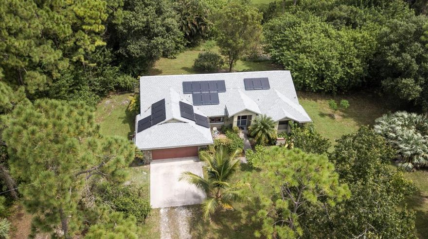 This recently updated CBS house on 1.31 acres is located in a very private & quiet location at the end of the road & boasts a less than 1 year old roof with new solar system which makes the current owner's electric bill virtually $0! This house has 3 bedrooms/ 2 bathrooms, 2 car garage & a beautiful kitchen with granite counter tops & stainless appliances which includes an upgraded gas stove/oven. This house is well prepared for hurricanes with clear panel shutters, fabric protection for the patio, an in-ground propane tank & is wired for a generator. The propane tank runs the stove, bbq & hot water heater. It also has a screened in patio, fenced yard, whole house vacuum system, 2 year old tankless water heater, 3 year old AC unit & is ready for you to move in to!