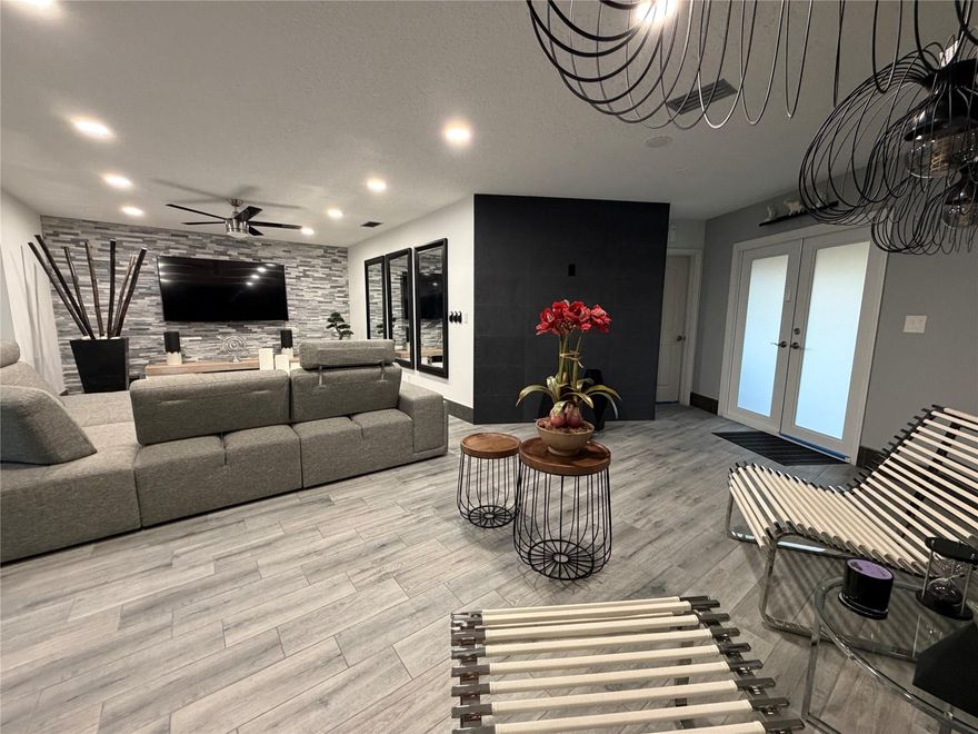 This beautifully renovated home offers over 2,000 square feet of comfortable living space. It features ceramic tile flooring throughout, 3 spacious bedrooms, and 2 modern bathrooms. The fully updated kitchen comes with granite countertops and stainless steel appliances. Enjoy ample social areas perfect for gatherings and everyday living. The property includes a two-car garage and additional parking space for up to 9 vehicles. Hurricane-resistant windows and doors provide extra safety and peace of mind. Ready for immediate move-in, this home combines modern finishes with natural and ceramic stone walls  with generous space both inside and out.