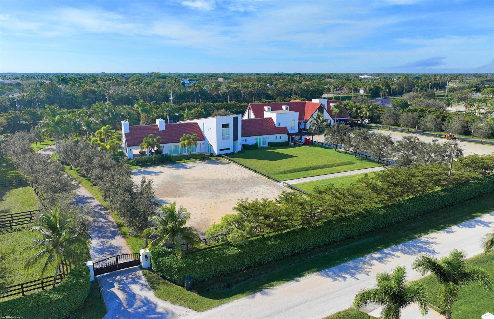 This premier gated equestrian estate in Saddle Trail is available for PRIVATE seasonal rental and offers an exceptional location just one mile from Wellington International, accessible via maintained bridle paths. PRICE REFLECTS THE SEASONAL MONTHLY RATE FOR THE ENTIRE FARM. A 4 MONTH MINIMUM LEASE TERM IS REQUIRED. Situated on over 4 acres, this turnkey property includes a thoughtfully designed 16-stall barn with full amenities, studio apartment, RV hookups, two all-weather arenas, a round pen, and eight grass paddocks. Four additional tent stalls can be added if required. The luxurious 4-bedroom, 5.5-bath residence features high-end finishes, marble flooring, chef's kitchen, gym, game room, and expansive outdoor living areas with a pool and summer kitchen, perfect for entertaining.