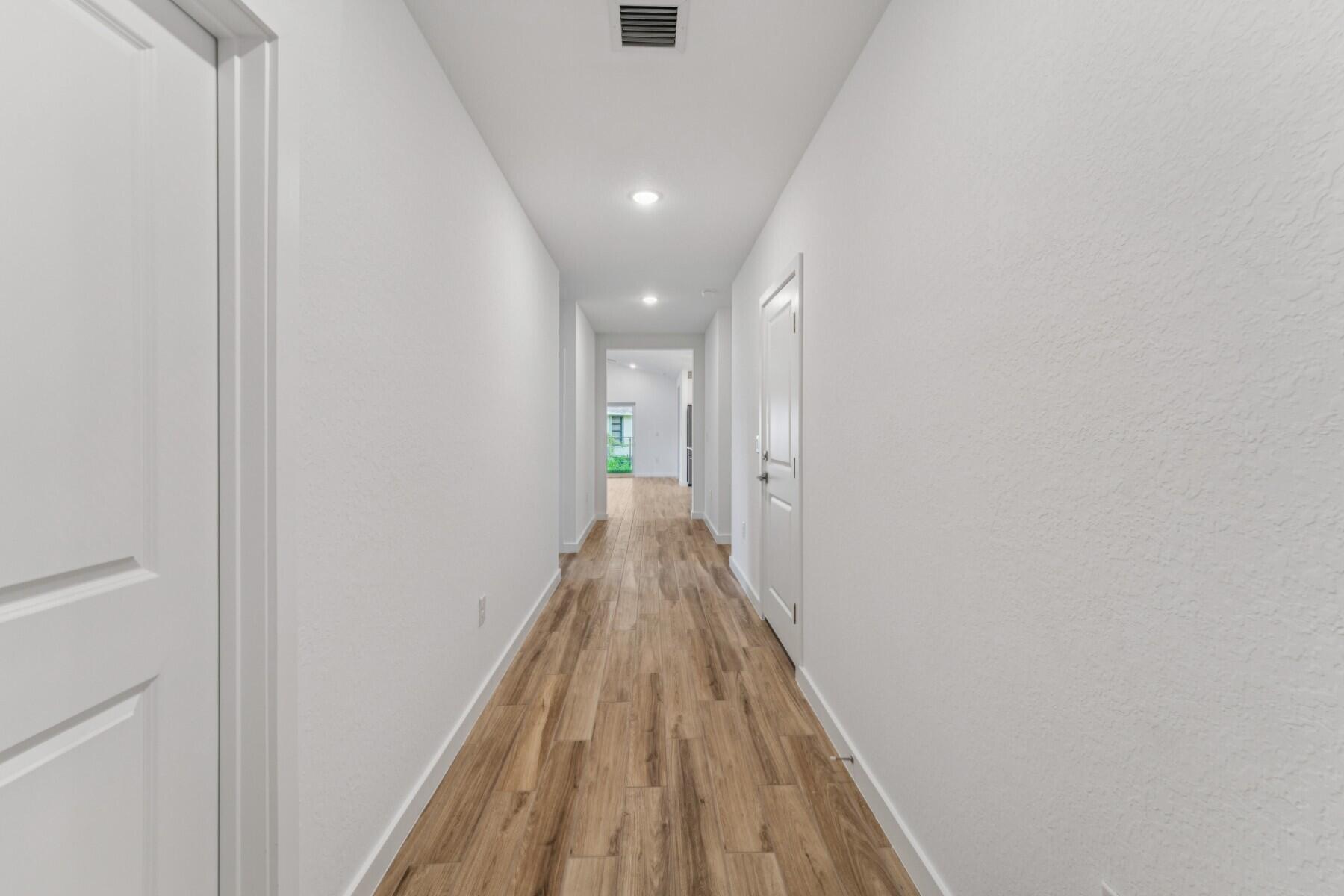 Oversized Residential Lot in Prime Port St. Lucie!This Passionflower II, set on a desirable oversized lot, combines thoughtful design with modern style. Oriented to the east, the home enjoys the beauty of early daylight and the promise of stunning sunrises. Inside, the Loft-inspired aesthetic showcases Brellin white cabinets and Carrara Miksa polished granite countertops, creating a fresh, streamlined look throughout.The floor plan includes an Extra Suite Plus with a private entry--ideal for multigenerational living or extended stays--complete with a wet bar in the living room for added convenience. The open-concept kitchen features a central island for prep and casual dining, complemented by modern pendant lighting and floating shelves that add both warmth and character.