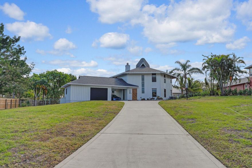 Nestled on a huge lot on the scenic bluffs of Hobe Sound, this stunning custom-built 4/2 home with New Roof in the prestigious Papaya Village offers a perfect retreat for nature lovers. Set on over half an acre at the crown of the bluff, the home captures the beauty of its natural surroundings blending seamlessly with the landscape. Designed to embrace the soothing ocean breeze, the home's unique hexagonal layout and custom vented cupolas enhance airflow and natural light, helping it blend seamlessly with the environment.  Newer high end Smart Kitchen Appliances, Wrap around Patio and Balcony and an abundance of parking are added features of this home. The home is currently leased through July. Come see it today!