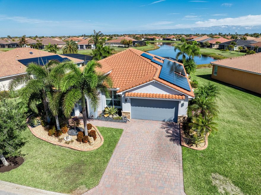 Stunning 4-bedroom, 3-bath home with den and a resort-style pool overlooking a breathtaking long lake view. This meticulously upgraded residence offers a blend of luxury and efficiency, featuring impact glass windows, a tile roof, whole-house generator, solar panels, new A/C, tankless water heater, full house water filtration system, and newer washer/dryer—all designed for peace of mind and modern living. The heart of the home is a gourmet kitchen showcasing high-end countertops, premium cabinetry, top-of-the-line lighting and fans, and an open layout that flows seamlessly into the family room and dining area. Every main living space is framed by panoramic views of the screened lanai, sparkling pool with spa and water feature, travertine flooring, and the picture-perfect lake beyond. The oversized primary suite is a private retreat with plantation shutters, custom walk-in closets, his-and-her vanities, and an expansive walk-in shower. Bedrooms two and three are located near the front of the home with a shared bath perfectly positioned between them. The fourth bedroom is versatile, ideal for guests or a home office, with a nearby full bath featuring a sleek seamless glass shower door. Additional upgrades include Toto toilets throughout, designer finishes, and thoughtful details at every turn. From the stunning lake views to the impeccable upgrades, this home delivers luxury living at its finest.