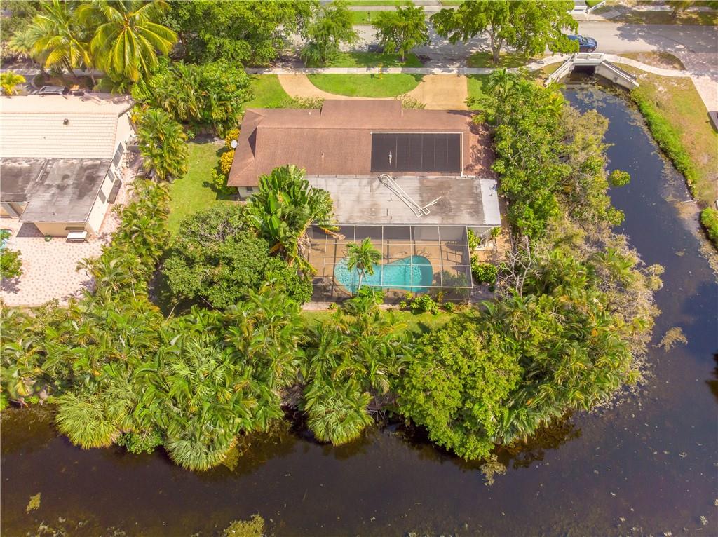 Great location in Plantation!! No Homeowners association for this 3 bedroom 2 and a half bath 2 car garage screened in pool home on over a quarter acre surrounded by water on 2 sides. Already have half a moat!!! Large outside covered area by the pool. Great for entertaining. Family room has built in wet bar. RENT INCLUDES LAWN AND POOL MAINTENANCE!!
