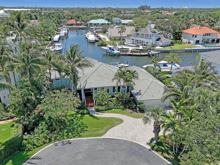 Unique custom -built home. 90 Foot dock with 12,000 K lift. Open floor plan includes 3 bedrooms with sliders to decks, office, 2 1/2 baths, dining room, living room with fireplace and exquisite built-in wood cabinets. Hardwood floors. 2 car garage with storage above. Impact glass. Pool with multi- level South African Hardwood decks, large, covered patio with fan, Cathedral ceilings with tongue and groove wood and exposed beams throughout. Primary bedroom two sets of sliders to exclusive private deck, view of Intracoastal waterway from East window. Wide water views. Boat lift set to the side to not obstruct view. Gated Bay Village, house on large Cul de sac setting home back from other homes providing privacy in back of home. Professionally designed lush landscaping, Orchids throughout