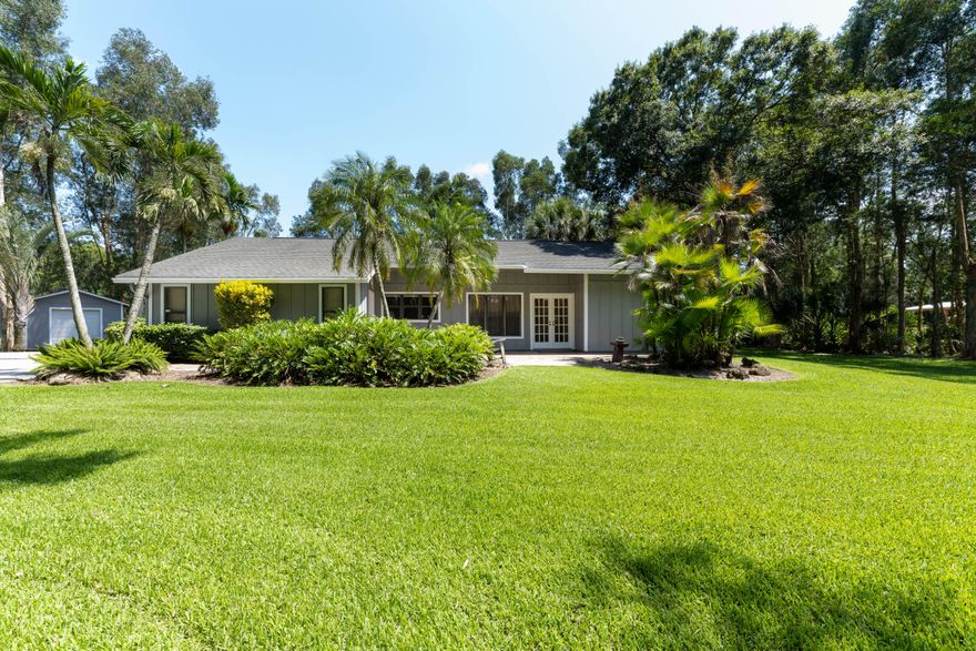 Enjoy the peace and quiet of your own slice of paradise in Jupiter Farms! No HOA! The best of both worlds, you can live the country life on a paved street close to the city! This lovely 3/2 home sits on 1.15 acres with lush landscaping plus privacy & plenty of tree shade. Fully fenced yard, ample parking, and a permitted shed for all your toys! The home features SS GE kitchen appliances, updated master bathroom, 'Mexican tile' throughout, and built-in closets. The garage door & opener replaced in 2020, new epoxy garage floor, AC system replaced in 2020. New roof 2007. Plenty of room for a pool. Bring your RV & boat. Horse trails galore! Enjoy all the benefits of living close to Riverbend Park & many more outdoor/natural amenities but close enough to Jupiter Town & everything it offers!!