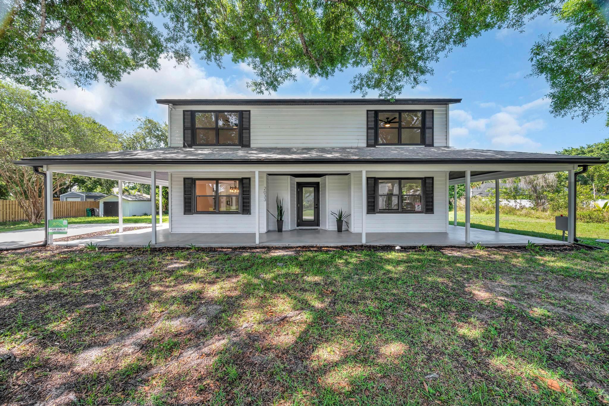 Fully renovated 2-story modern farmhouse on an oversized lot with no HOA--just minutes from Tradition! Enjoy the freedom to add a guest house, detached garage, or workshop. This move-in-ready home features a newer roof (2022), two brand-new A/C units, and all-new waterproof laminate flooring throughout. The chef's kitchen is outfitted with custom hardwood cabinetry, quartz countertops, soft-close drawers, and never-used stainless steel appliances. Other upgrades include impact-rated exterior doors, new interior doors, and high-end lighting and ceiling fans throughout. Outside, enjoy a large wraparound porch, spacious yard, mature oak trees and a large pool and covered patio area ideal for entertaining, relaxing, or future enhancements. Schedule your private showing today!