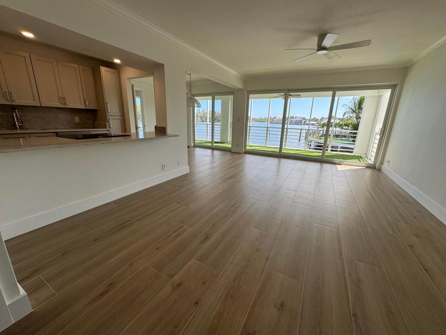 Rare waterfront 2BR/2BA residence with distinctive Frank Lloyd Wright-inspired architecture and no shared walls, offering exceptional privacy and the feel of a private home. This rare layout places the full length of the residence along the Intracoastal, allowing both bedrooms, dining area, and living room to capture direct water views. Expansive covered lanai extends across the primary suite and main living spaces for seamless indoor-outdoor living. Elegant updated kitchen features solid wood cabinetry in a refined pebble finish, soft-close drawers, pantry, new appliances, and Taj Mahal quartzite countertops. Impact windows, new A/C, new water heater, washer/dryer, and wood-look porcelain tile complete the home.