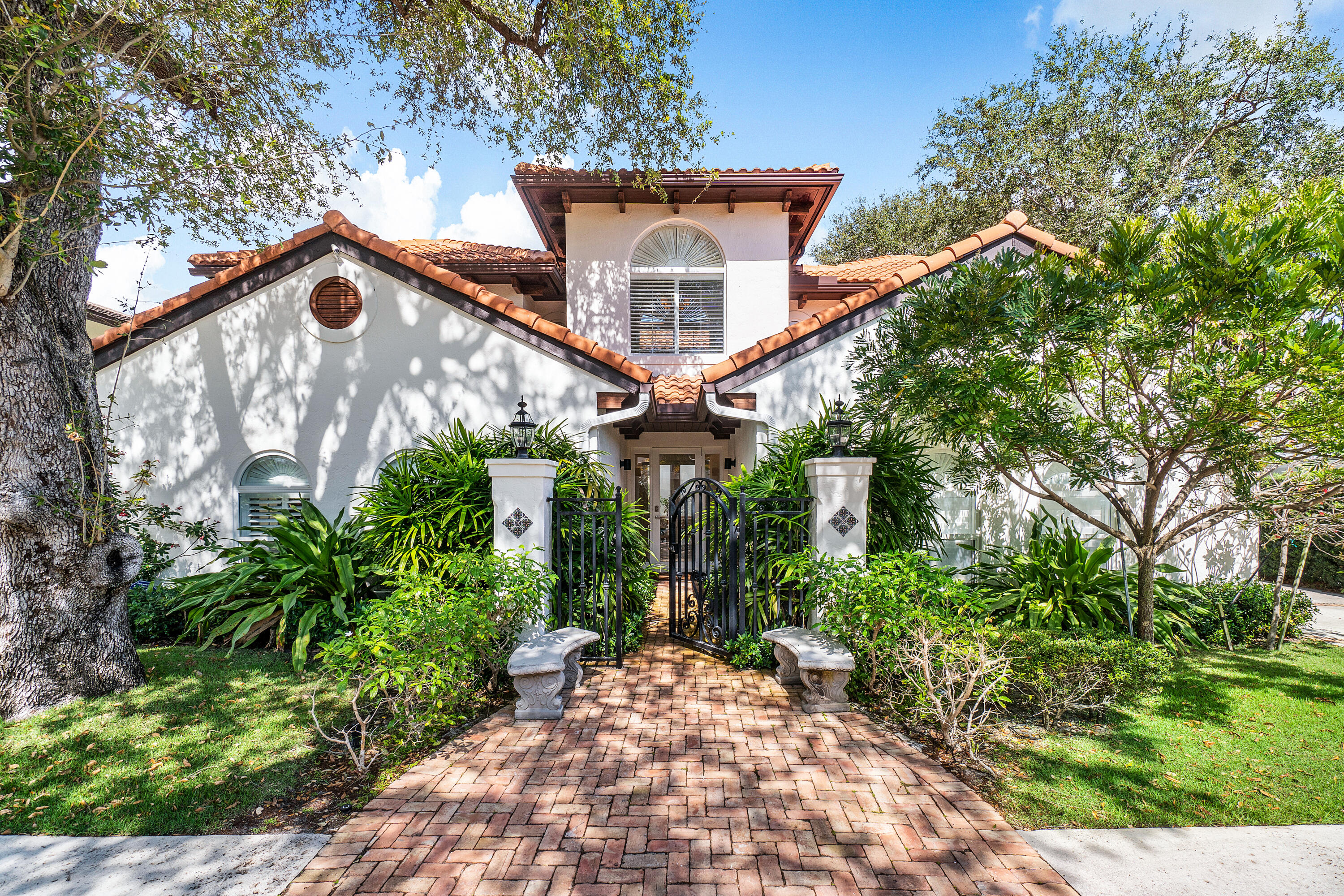 Nestled among beautiful Banyan & Oaks trees comes this exceptional Mizner-Style Estate in the Old Floresta/Tunison Palm neighborhood in Boca Raton. Featuring 4,495 total square feet this home offers an easy floor plan surrounding the two-story open central interior atrium, a very special & unique feature! This estate boasts 5 bedrooms, a den/office, 3.5 baths, & a 2nd floor yoga/reading area. The chef's kitchen with gorgeous quartzite countertops & custom butcher block on a quartzite island with built-in microwave & seating area is the perfect spot for family get togethers. Viking Gas range/ovens, Sub Zero appliances, & a desk area complete the kitchen. This open concept kitchen flows easily into the dining area & the family room with fireplace. French doors open to the pool area &