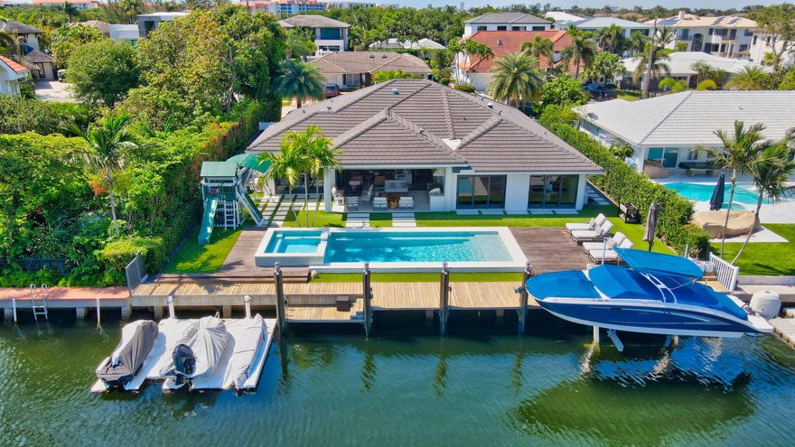 Spectacular waterfront home! Prime Intracoastal location less than 1 mile walk to the beach! Desirable Lake Rogers neighborhood is quiet yet close to the action of downtown Boca/Delray (5-10 min) and Ft.Laud/WPB/Miami (30-45 min). This home was completely renovated/expanded in 2016 w/ the finest of touches. Exterior Features: Large yard, landscape lighting (front/back), clean landscape, Turf, 10,000 lb Boat Lift, 3-Position Floating Dock, DCS Summer Kitchen with Refrigerator/Ice Maker/Grill, Full Impact Windows/Doors, Whole House Generator, Natural Gas, Saltwater/Heated Pool with WiFi controls, Circular Driveway, Roof (2016), Electric and Plumbing (2016), tankless water heater (2016). Interior Features Include: Gourmet Kitchen with custom cabinets/extra storage under island/pantry, natural gas Wolf range, SubZero refrigerator and wine fridge, Wolf double ovens, Bosch dishwasher, large over-sized island makes this space luxurious and comfortable with amazing water views.  Unique upgrades include: an electric screened porch and a full wall of folding doors that make inside and outside one room. Primary Bedroom is open with large doors that allow a beautiful water/pool view, 2 walk-in closets and separate shower and tub. 2nd and 3rd  bedrooms also have large doors and water/pool view. 4th bedroom has a walk-in closet and on-suite bathroom.  All bathrooms are tastefully upgraded with LED luminous mirrors, herringbone tile pattern, and designer fixtures. Engineered wood floors, Hunter Douglas Silhouette Blinds throughout, stereo system with whole-home built in speakers. See attached for all features.